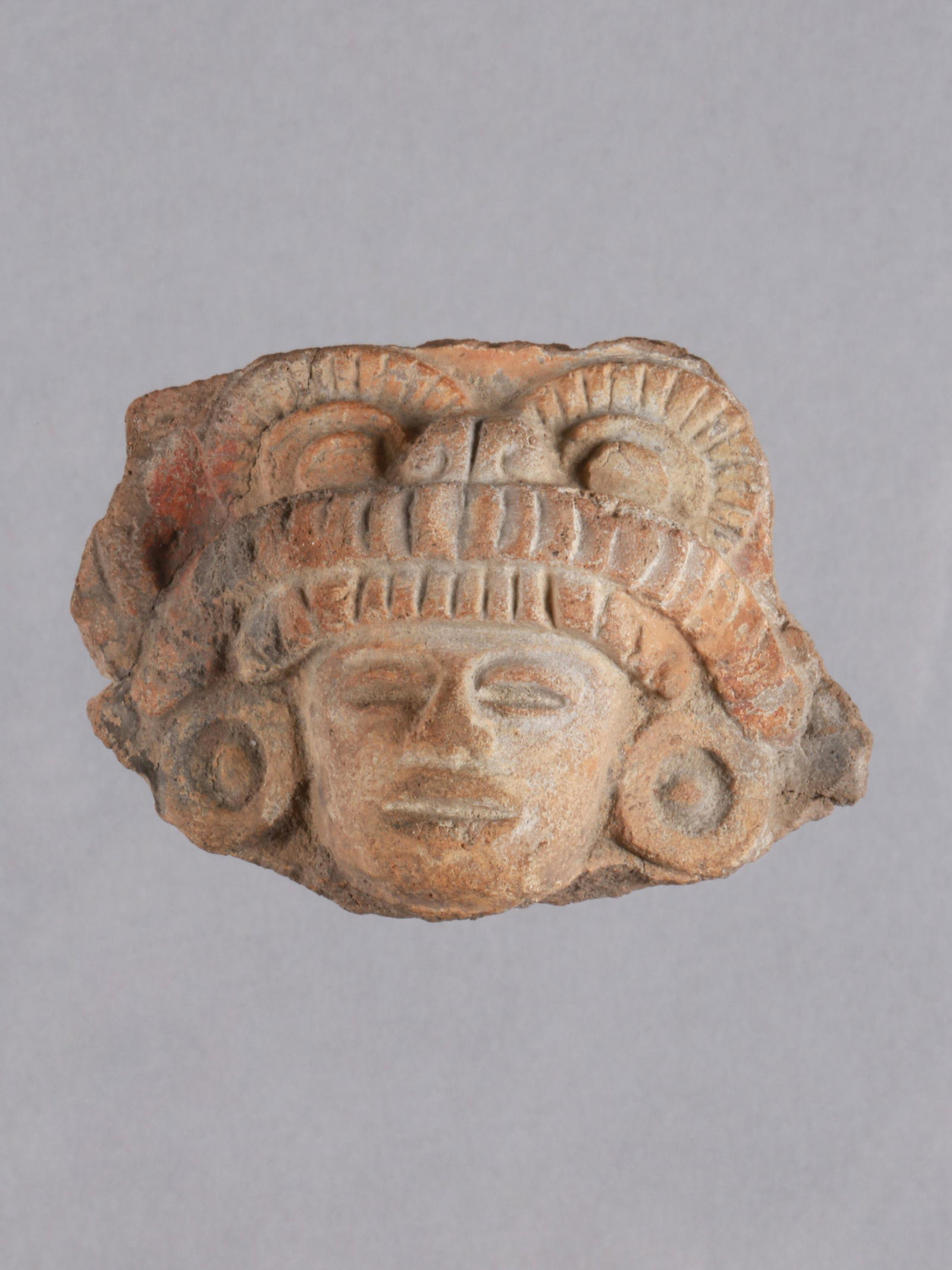 A Veracruz Face: Terrakotta-Antlitz Veracruz Kultur, Mexiko Ohne Sockel / without base Terrakotta. H 4,5 cm. Provenienz: Nachlass Robert Guy, Basel. CHF 20 / 40 EUR 17 / 34