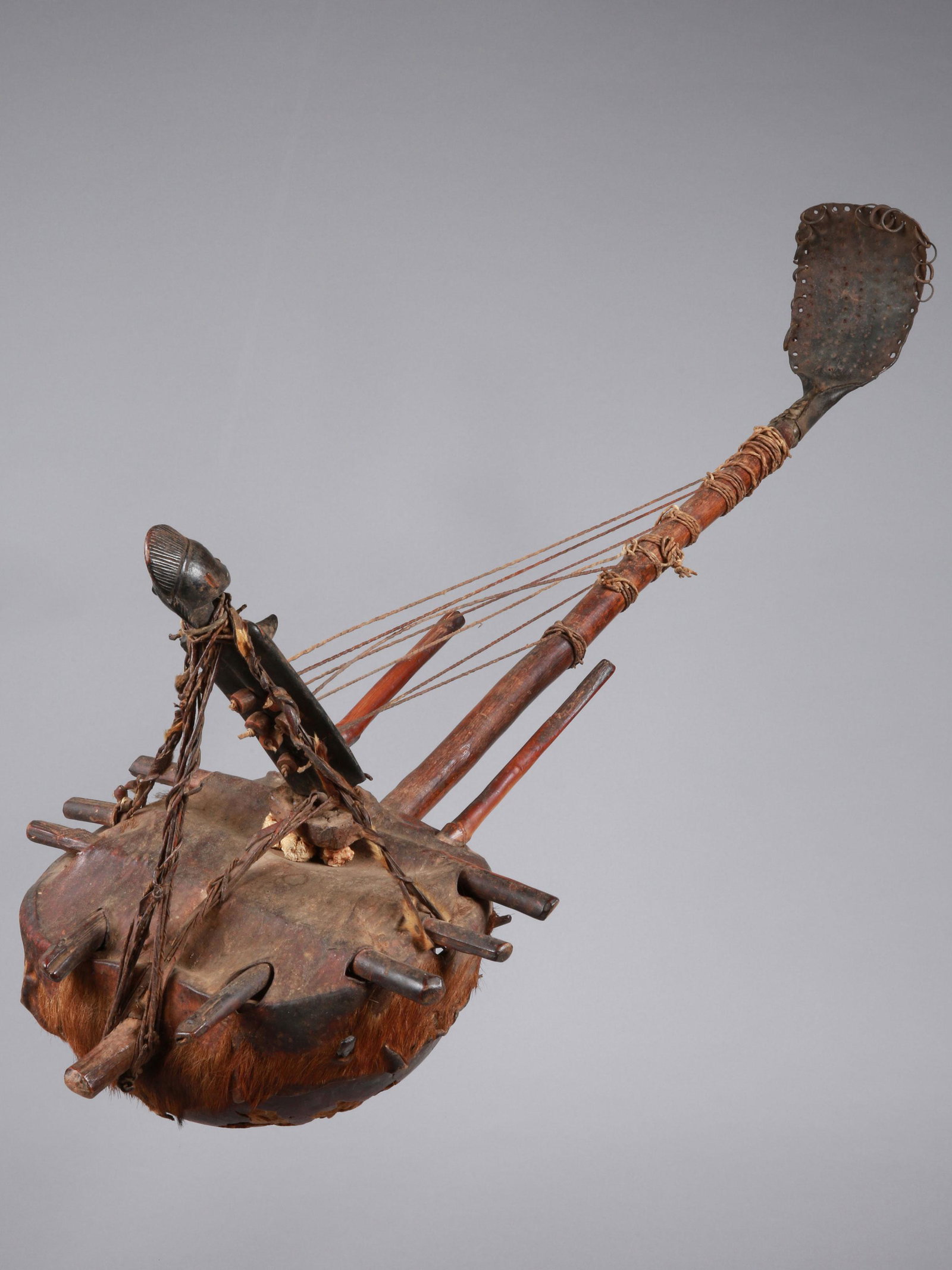 A Senufo Harp, "korikaariye": Saiteninstrument, "korikaariye" Senufo, Côte d’Ivoire Ohne Sockel / without base Kalebasse, Leder, Holz, Eisen. H 98 cm. B 38 cm. Provenienz: Helmut und Marianne Zimmer, Zürich. Die Harfe ist eine