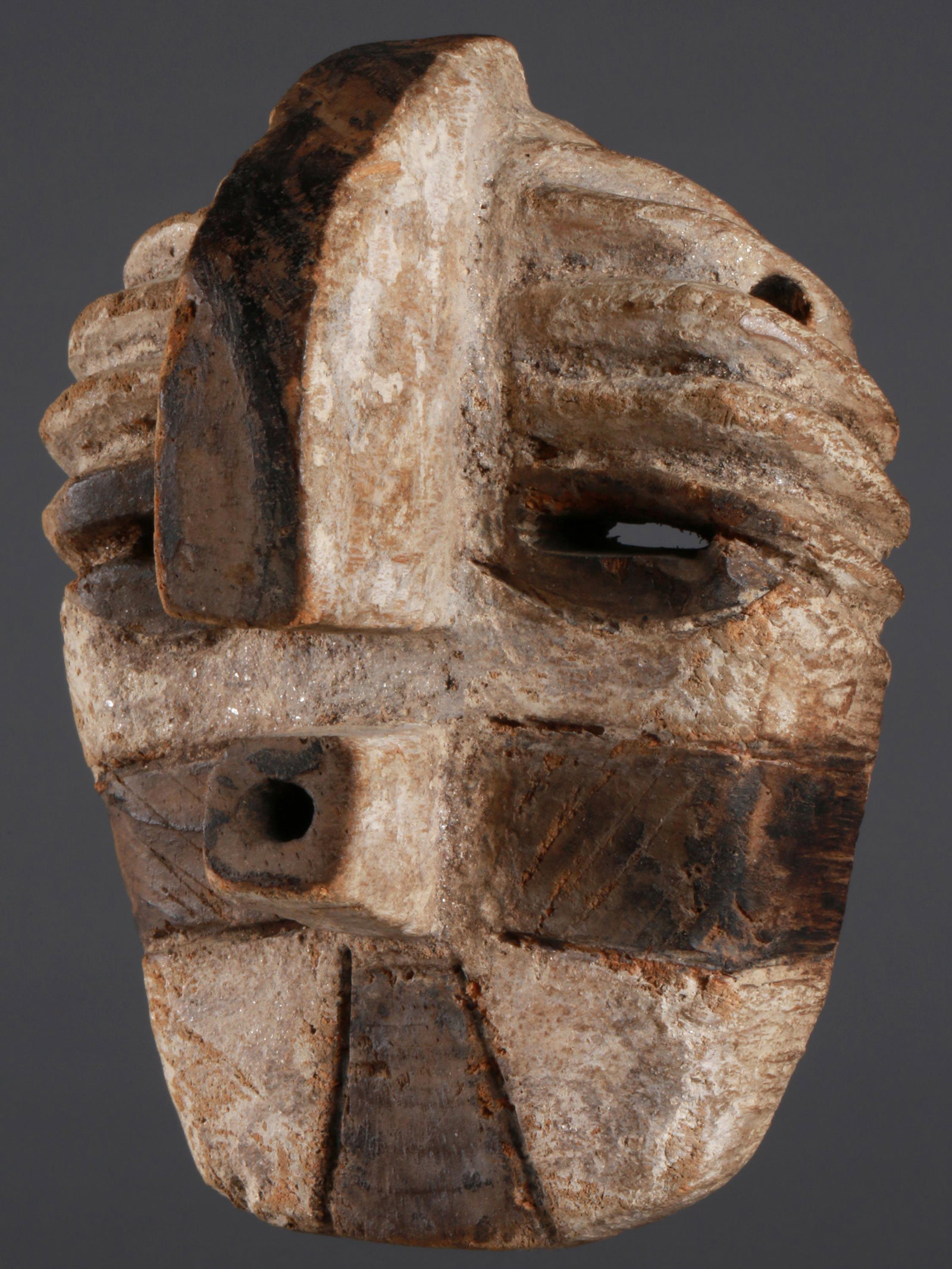 A Songye Miniature Mask: Minatur-Maske Songye, DR Kongo Ohne Sockel / without base Holz. H 10 cm. Provenienz: Helmut und Marianne Zimmer, Zürich. Persönliche Miniatur einer wesentlich grösseren Kifwebe Maske. Initiierte ha