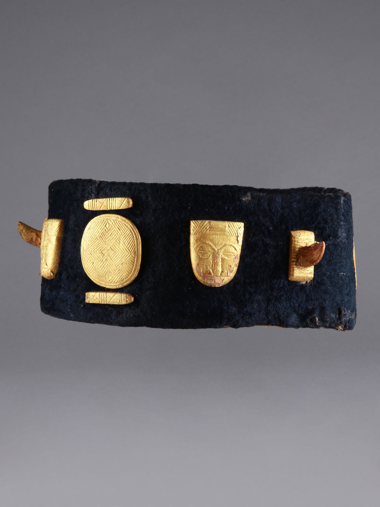 An Akan Crown: Stirnband, Krone Akan, Côte d’Ivoire Ohne Sockel / without base Textil, Holz, Goldfolie. H 8 cm. Ø 18 cm. Provenienz: - Galerie Walu, Zürich (1996). - Nachlass Dr. Andreas Vontobel (1931-2011), W