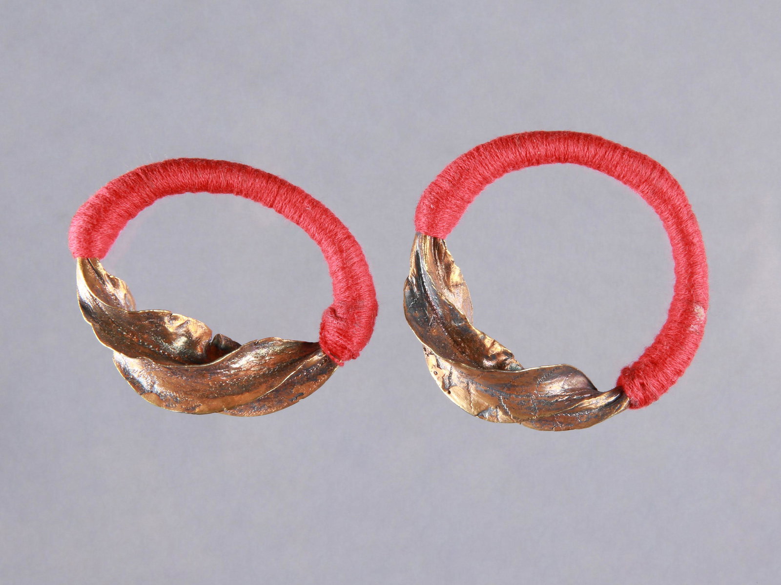 A Peul Pair of Ear Ornaments, "kwoteneye kange": Ohrschmuck-Paar, "kwoteneye kange" Peul, Mali Ohne Sockel / without base Silber, Feingehalt: 900, vergoldet, Baumwolle. Ø 5 cm. Provenienz: Andreas Vontobel (1931-2011), Waltalingen. Als Hochzeitsges