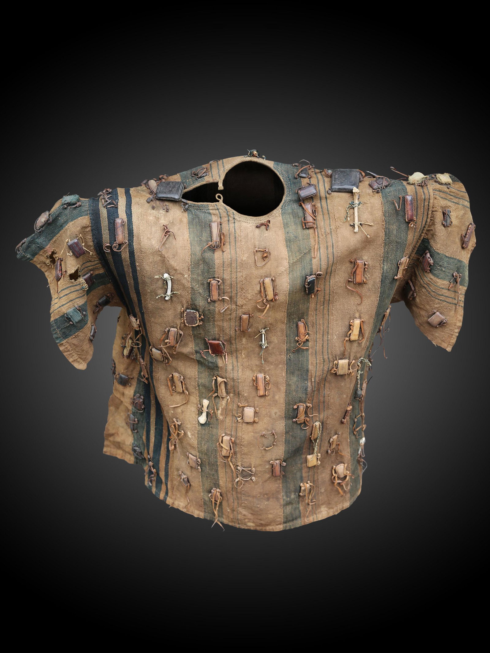A Senufo Tunic: Jäger-Tunika Senufo, Côte d’Ivoire Ohne Sockel / without base Baumwollgewebe, Leder, Knochen. B 112 cm. L 95 cm. Provenienz: Nachlass René David (1928-2015), Zürich. Ausgestellt: Musée Internat