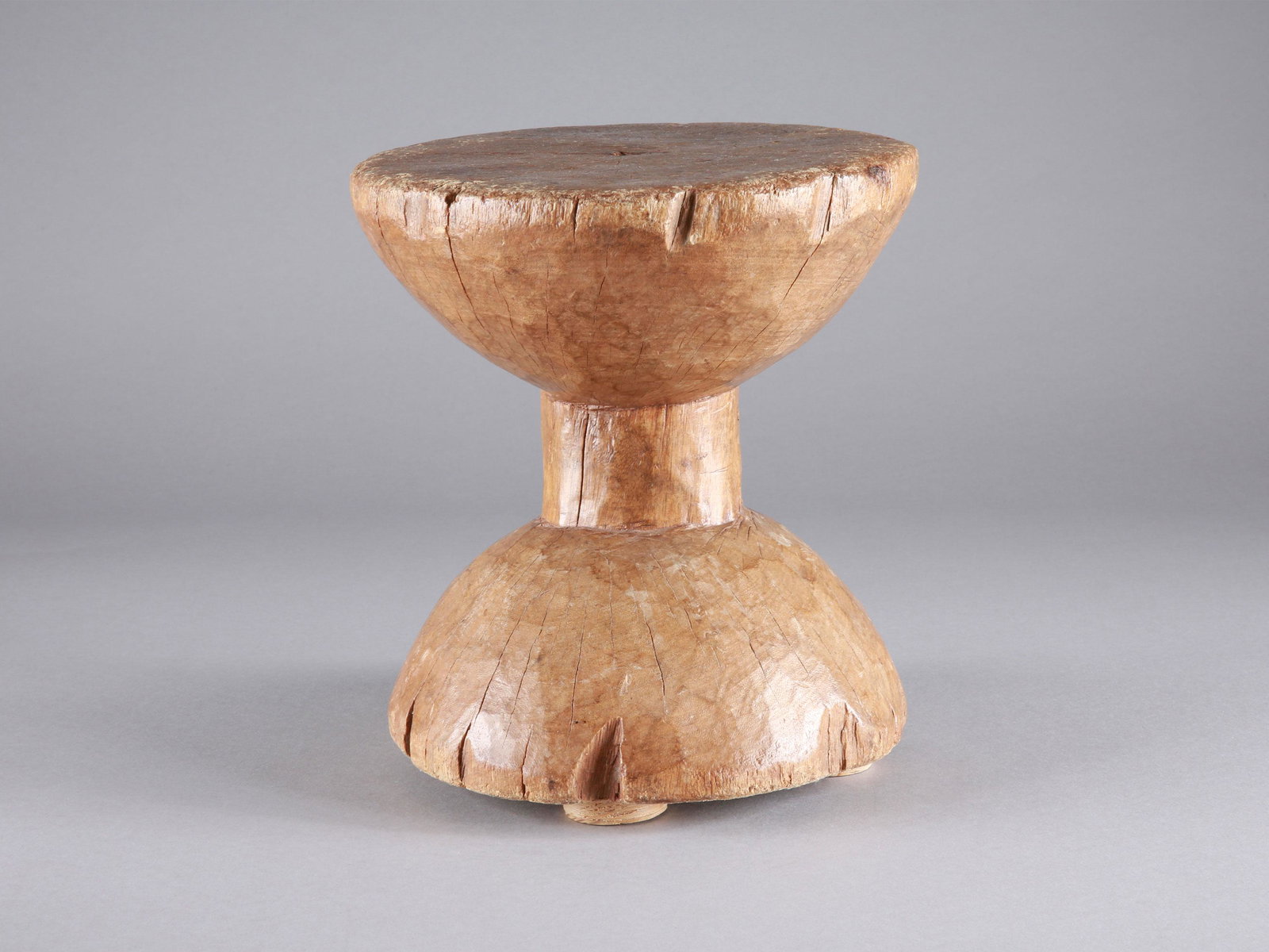 A Dan Seat, "bo ya kbolo": Sitz, "bo ya kbolo" Dan, Côte d’Ivoire Ohne Sockel / without base Holz. H 25 cm. Ø 22 cm. Provenienz: Kurt Hösli-Brutschin (1928-2006), Basel. Die Verbindung von Nützlichem und Schönem wird ins