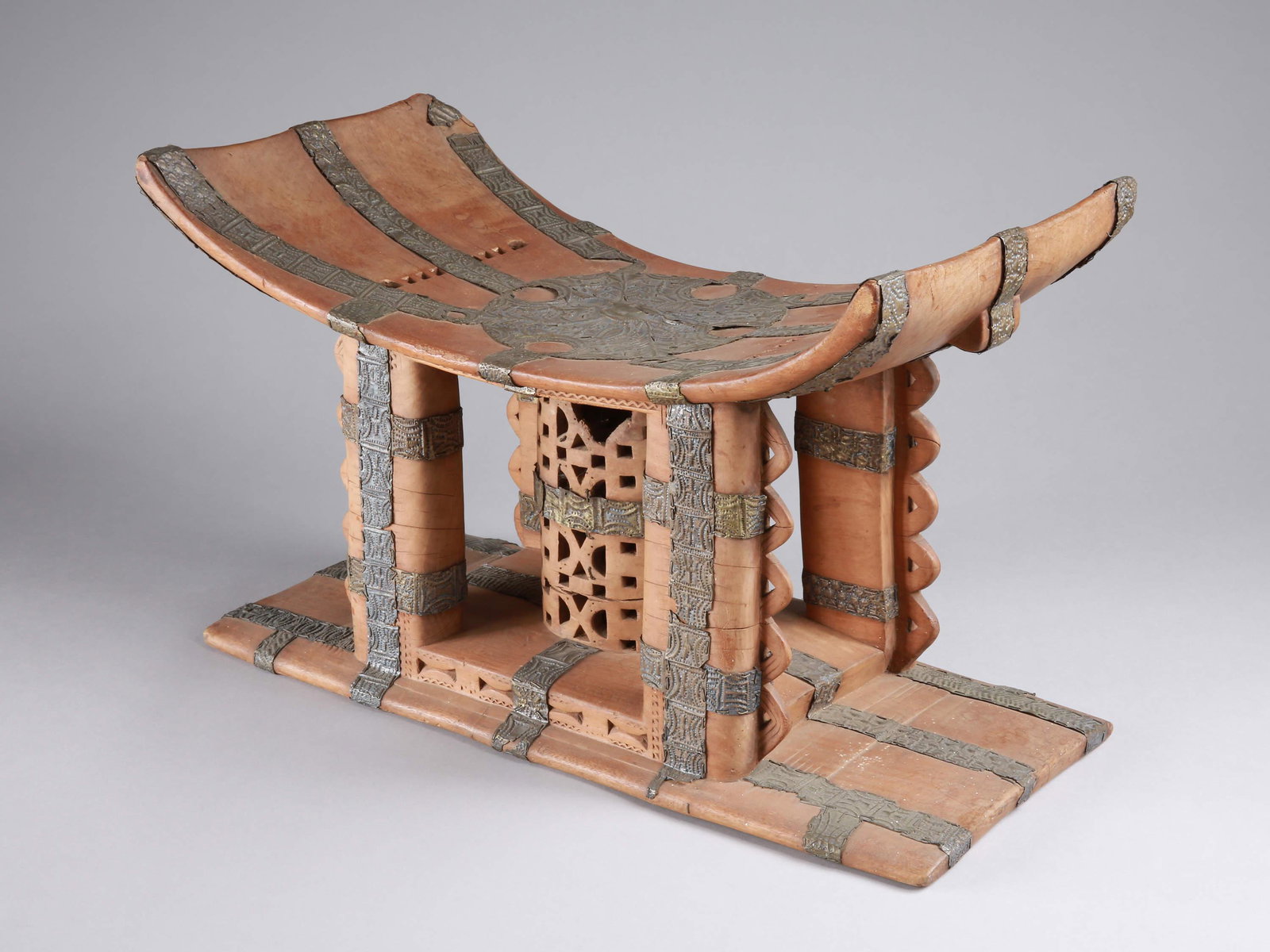 An Asante Stool, "adamu dwa": HÃ¶fischer Sitz, "adamu dwa" Asante, Ghana Ohne Sockel / without base Holz, Bronze. H 34,5 cm. B 56 cm. Provenienz: - RenÃ© und Denise David, Kilchberg. - RenÃ© David (1928-2015), ZÃ¼rich (200