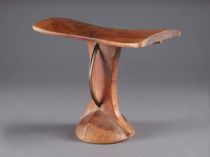 A Karamojong Headrest, "ekechelong": Karamojong Nackenst&#252;tze, "ekechelong" Karamojong / Turkana, Uganda / Kenia Ohne Sockel / without base Holz, Eisen. H 20 cm. B 25,5 cm. Provenienz: Evan Maurer, Minneapolis. Nackenst&#252;tzen wur