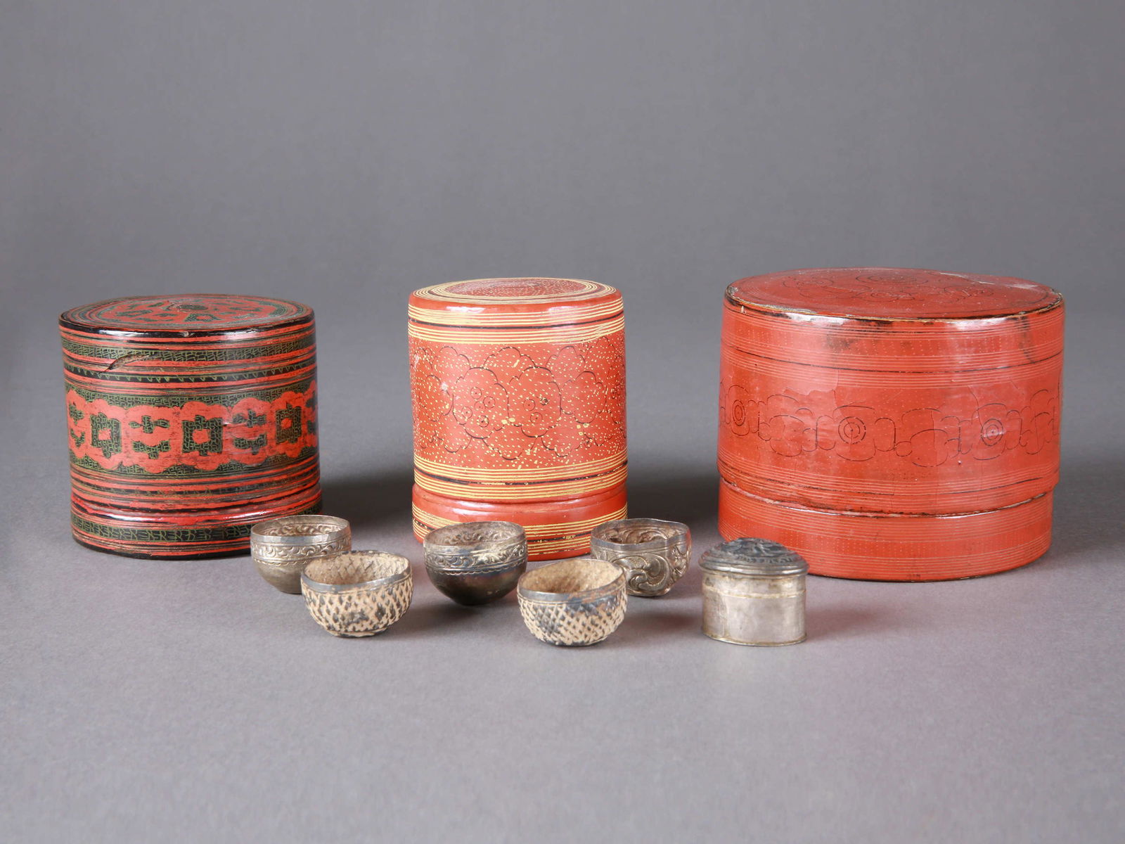 3 Burmese Betel-Containers ("kun-it") and 6 hollow hemispheres: 3 Betel-Behälter ("kun-it") und 6 hohle Halbkugeln Burma Ohne Sockel / without base Lackiertes Geflecht, Silber. H 5,5 - 6,5 cm. Ø 5 - 8 cm. Provenienz: Schweizer Privatsammlung, Basel. Alle