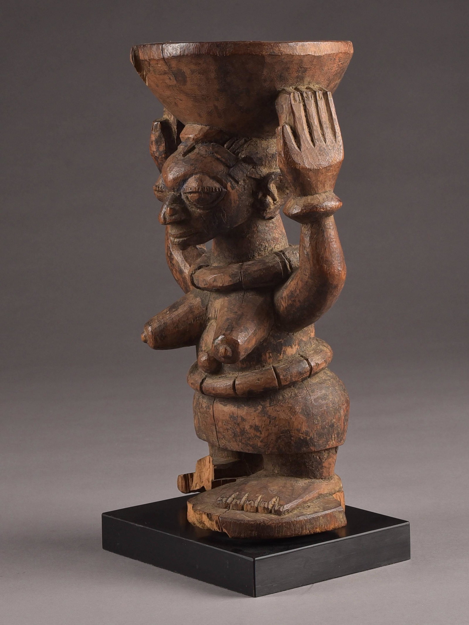 A Yoruba Bowl bearing Figure, "arugba shango": Schalenträgerin, "arugba shango" Yoruba, Nigeria Mit Sockel / with base Holz. H 39 cm. Provenienz: - lt. Besitzer: Galerie 62 / Maud & René Garcia, Paris (1970er Jahre). - Helmut (1931-2021)