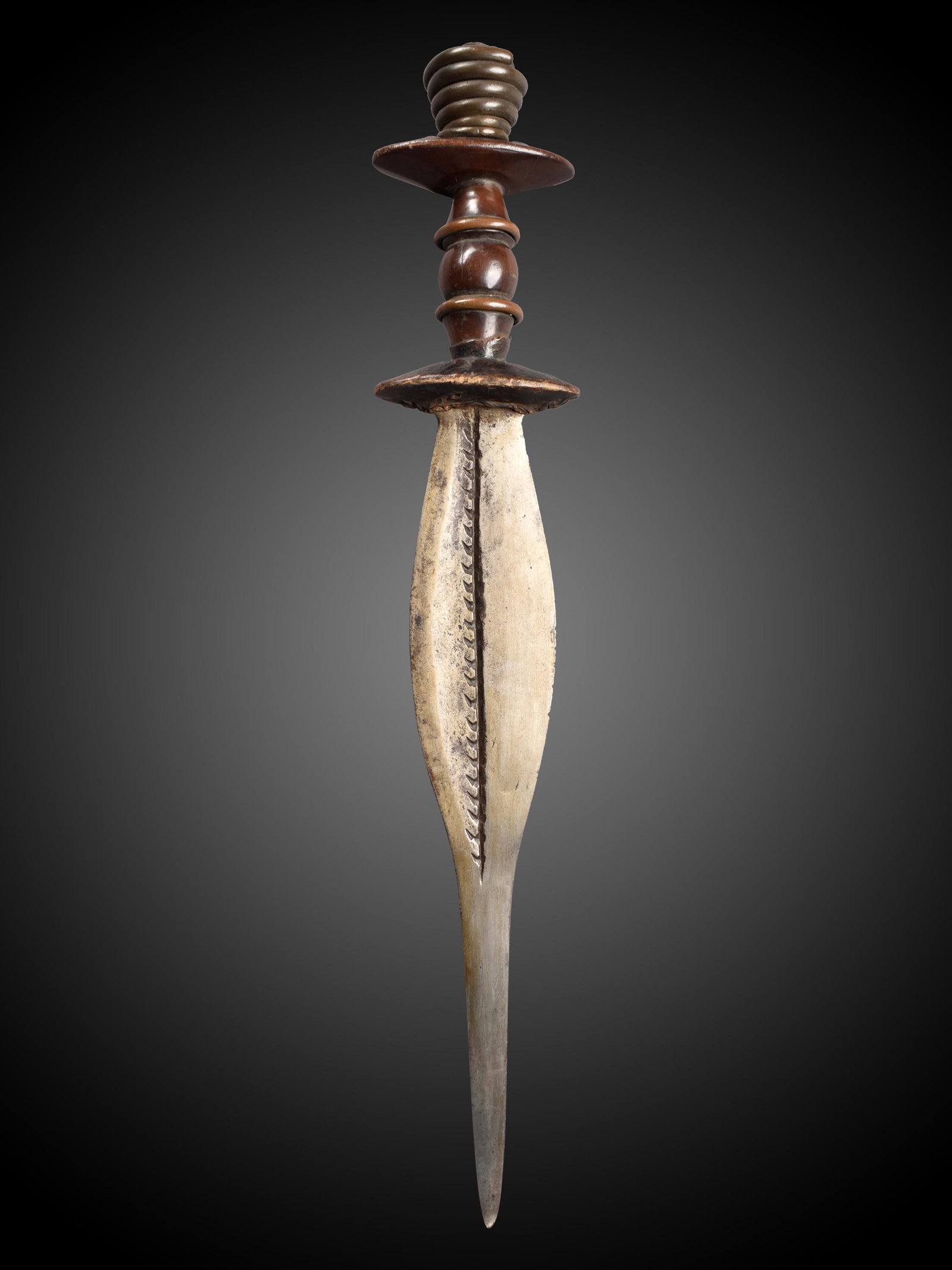 An Igbo Ceremonial Dagger: Zeremonial-Dolch Igbo, Nigeria Ohne Sockel / without base Holz, Eisen. H 48 cm. Provenienz: Helmut (1931-2021) und Marianne Zimmer, Zürich. Zeremonialwaffen zeichnen sich durch sorgfältige H