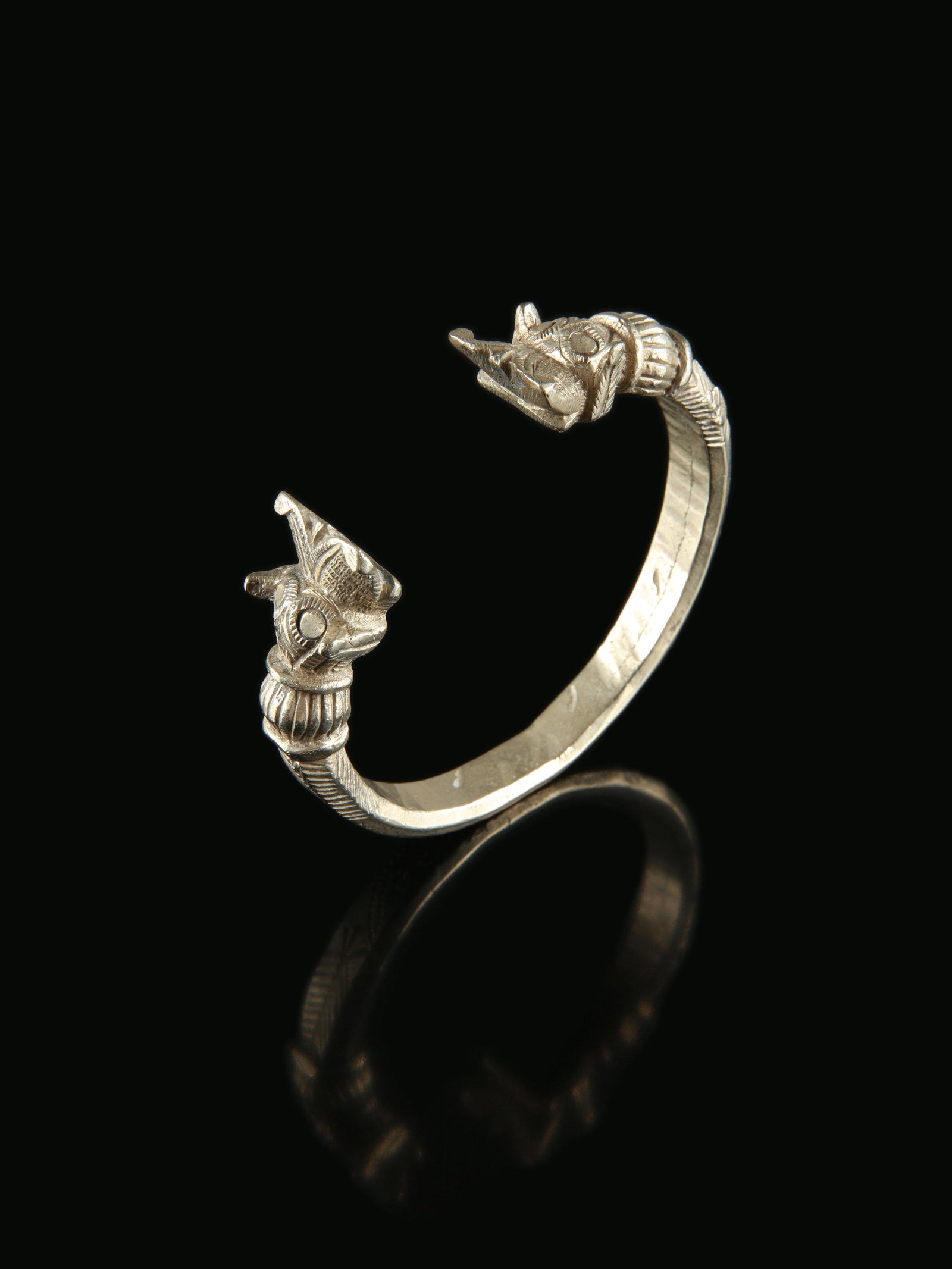 A Tibetan Bangle: Armreif Tibet Ohne Sockel / without base Silber. H 8 cm. B 8,5 cm. Provenienz: Schweizer Privatsammlung, Zürich. Bangle cracked in the middle (see photos). Reif in der Mitte angebrochen (siehe Fo