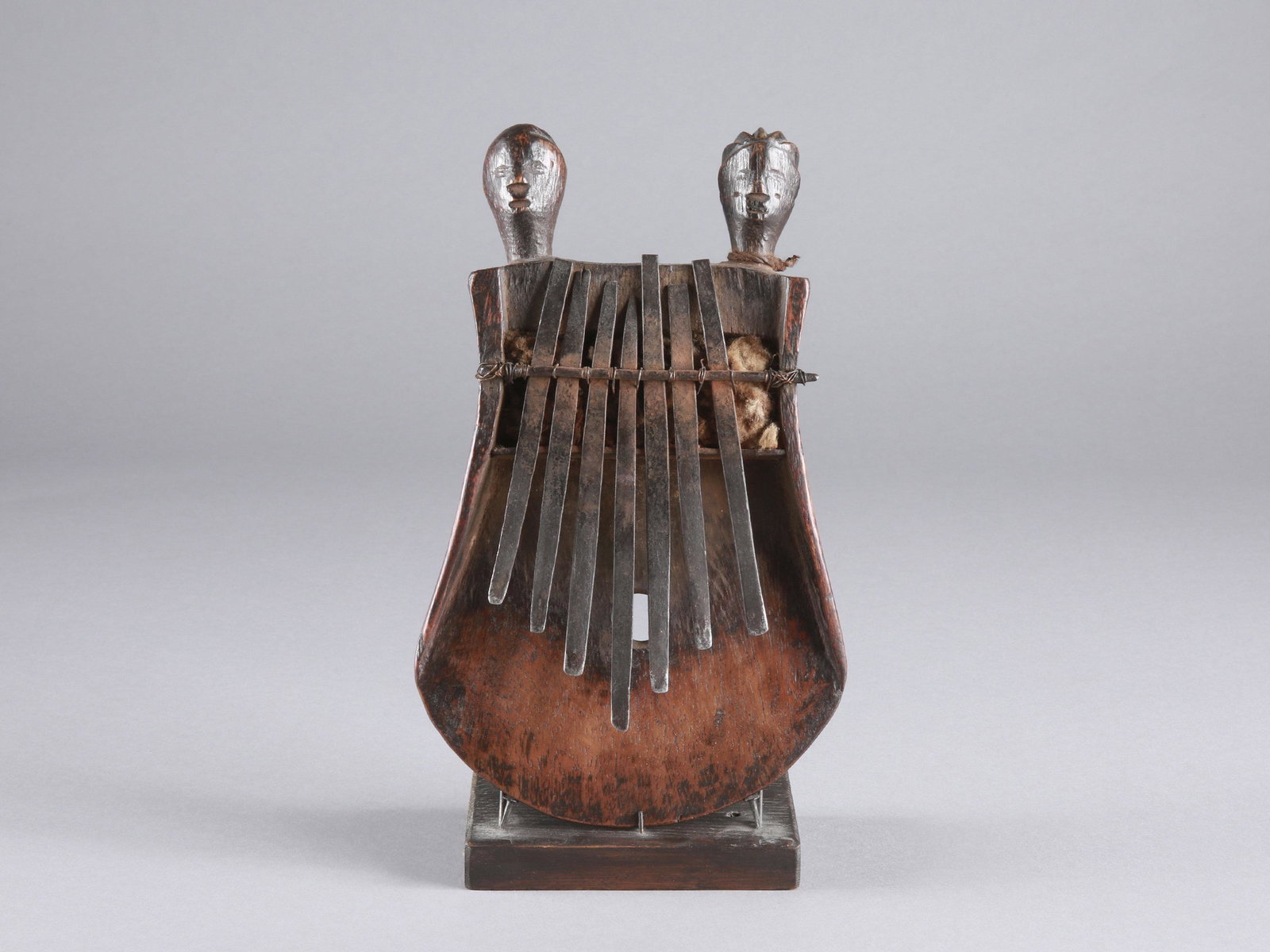A Rungu Sanza, Lamellaphone, "kankobele": Sanza, Lamellophon, "kankobele" Luba-Tabwa complex, Rugu (?), DR Kongo Mit Sockel / with base Holz, Eisen. H 22 cm. B 13,5 cm. Provenienz: Peter Stettler (1939-1998) und Erica Stettler-Schnell (1940-2