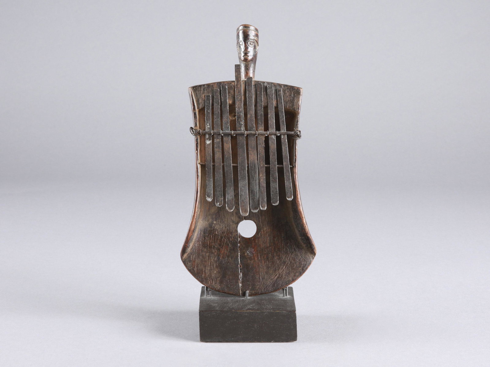 A Rungu Sanza, Lamellaphone, "kankobele": Sanza, Lamellophon, "kankobele" Luba-Tabwa complex, Rugu (?), DR Kongo Mit Sockel / with base Holz, Eisen. H 21,5 cm. B 11 cm. Provenienz: Peter Stettler (1939-1998) und Erica Stettler-Schnell (1940-2