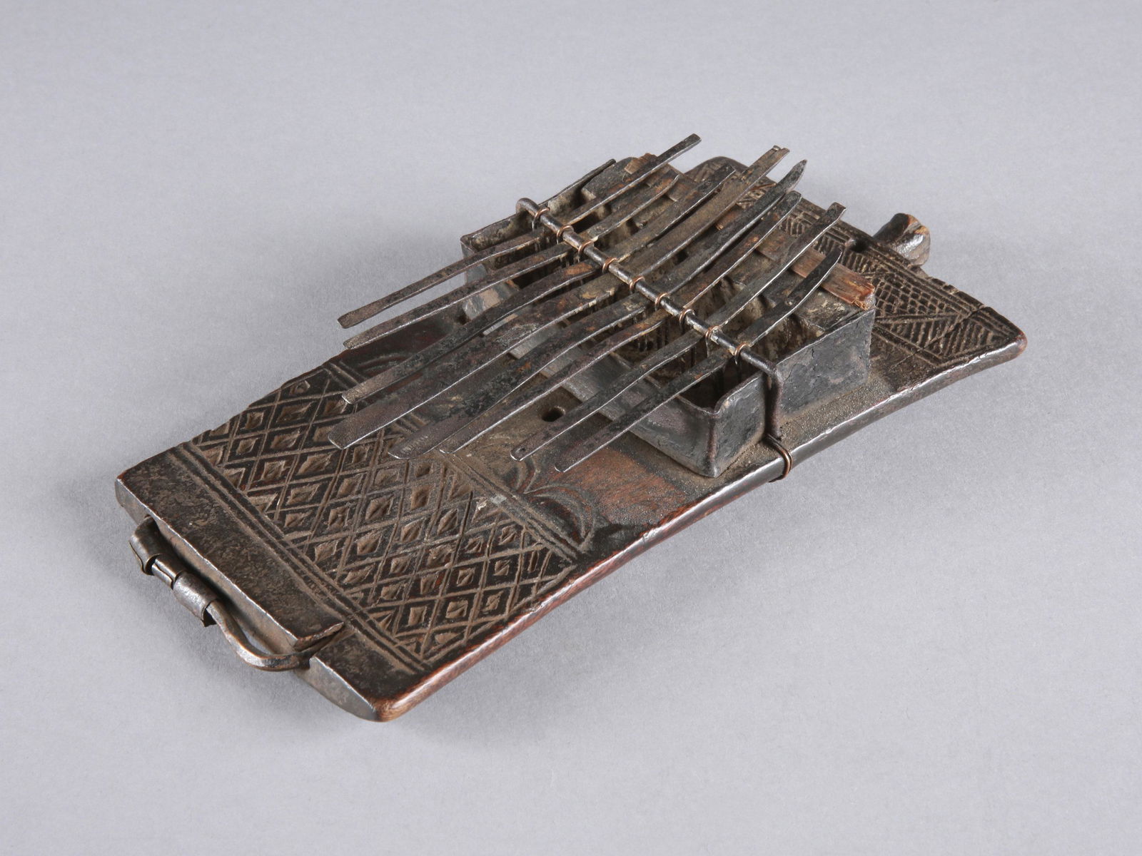 A Chokwe Lamellaphone, "tyitanzi": Sanza, Lamellophon, "tyitanzi" Chokwe, DR Kongo Ohne Sockel / without base Holz, Eisen. H 19,5 cm. B 9,5 cm. Provenienz: Peter Stettler (1939-1998) und Erica Stettler-Schnell (1940-2019). Sanza, "Daum