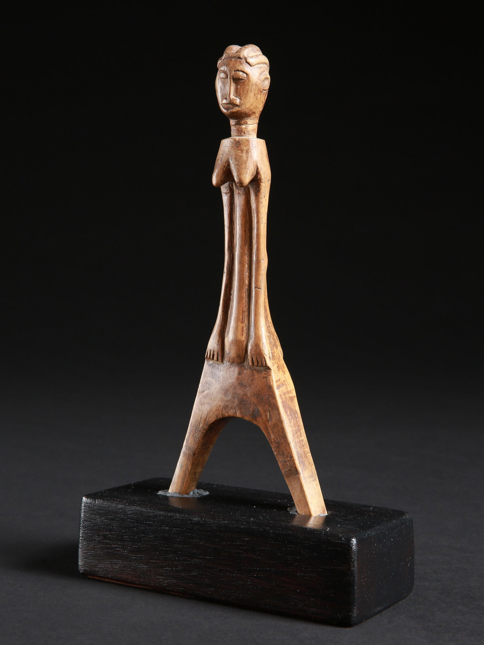 An Akan Slingshot, "potomowaka": Steinschleuder, "potomowaka" Akan, Côte d’Ivoire Mit Sockel / with base Holz. H 21,5 cm. Provenienz: - Madeleine und Jean-Jacques Keller, Rheinfelden, Schweiz. - Hammer Auktionen, Basel, Sc