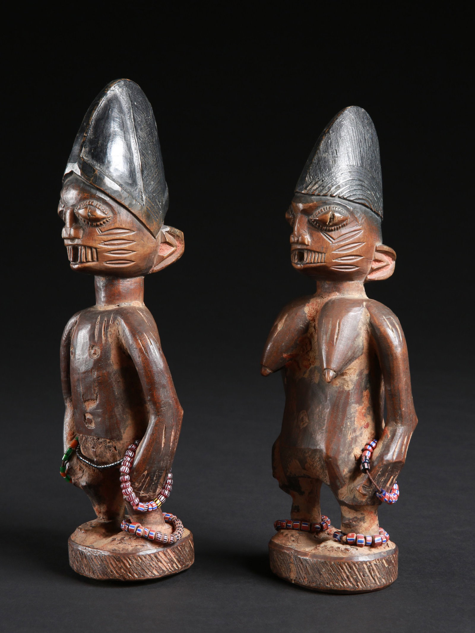 A Yoruba Pair of Twin Figures, "ere ibeji": Zwillingsfigurenpaar, "ere ibeji" Yoruba, Nigeria Ohne Sockel / without base Holz, Glasperlen. H 25 - 27 cm. Provenienz: Beatrice Leutert und Marcel Plüss, Thurgau, Schweiz. Über Zwillinge w