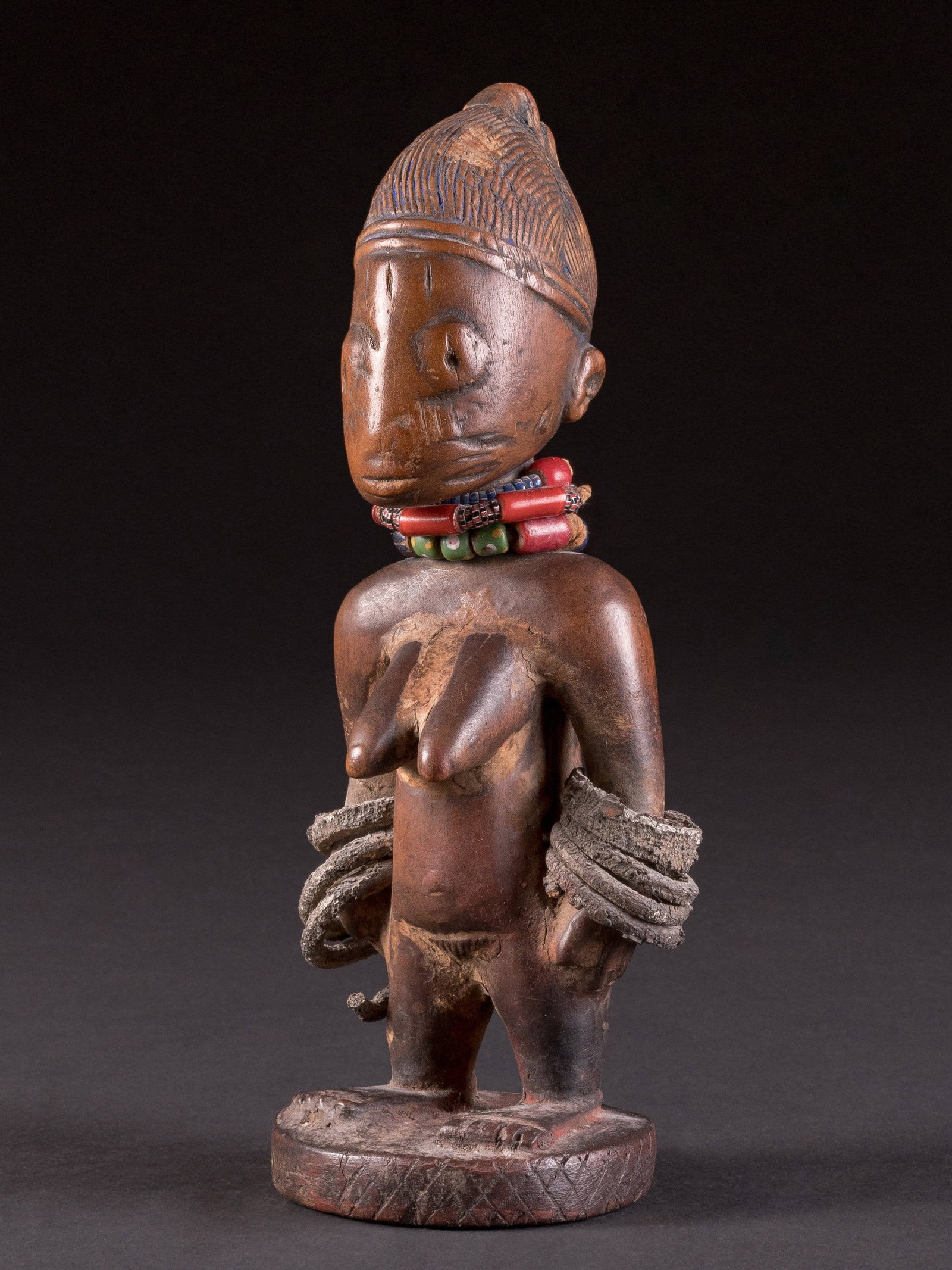 A Yoruba Twin Figure, "ere ibeji": Zwillingsfigur, "ere ibeji" Yoruba, Nigeria, Oyo State, Gegend von Shaki (Stadt) Ohne Sockel / without base Holz, Glasperlen, Metall. H 21 cm. Provenienz: Schweizer Privatsammlung (Inv. Nr. 73-109 auf