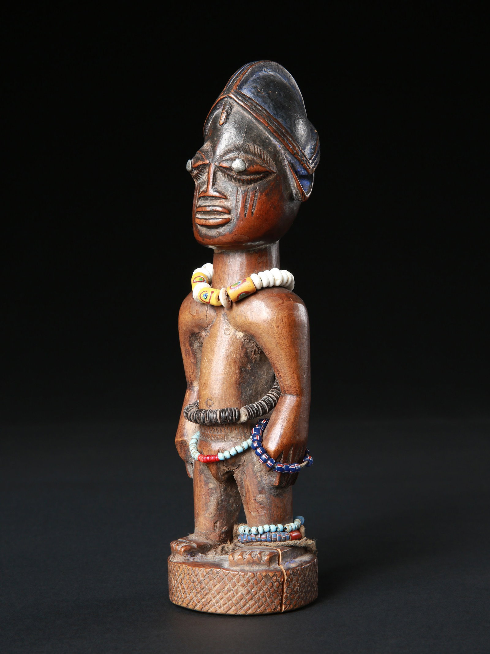 A Yoruba Twin Figure, "ere ibeji": Zwillingsfigur, "ere ibeji" Yoruba, Nigeria Ohne Sockel / without base Holz, Glasperlen. H 23,5 cm. Provenienz: Schweizer Privatsammlung, lt. Besitzer vor 1992 in Lomé erworben. Über Zwillin