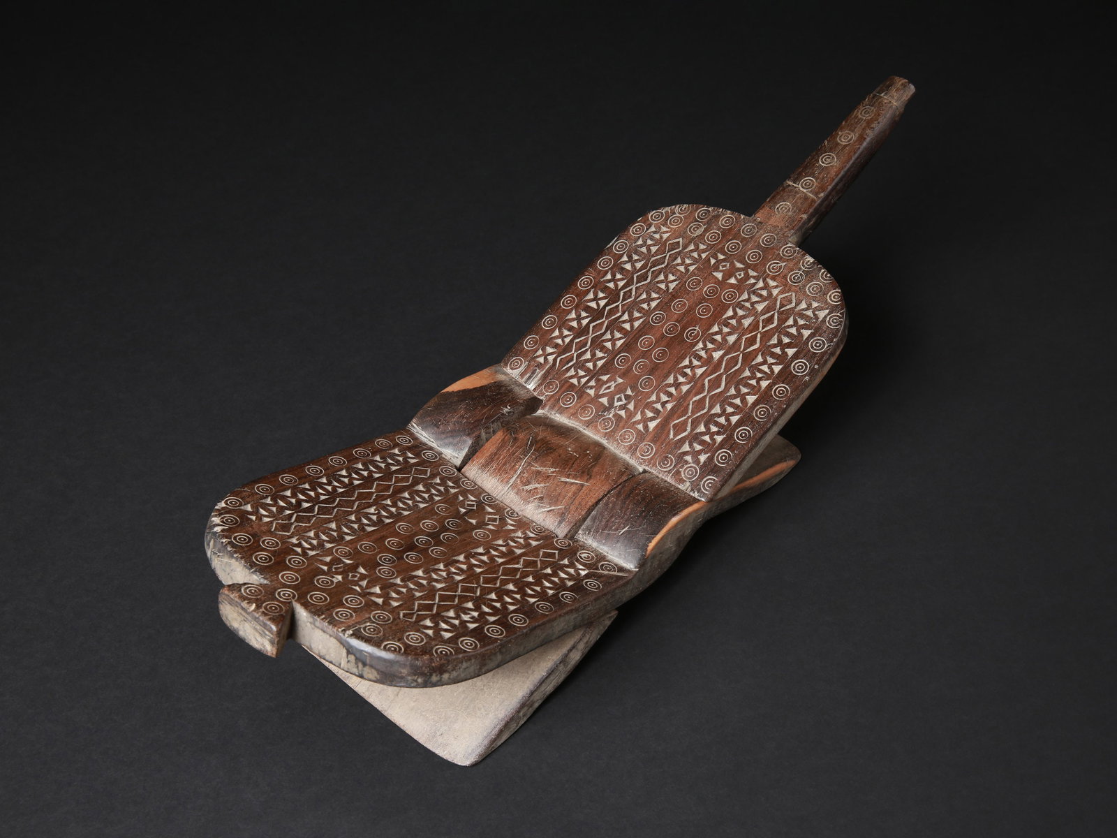 A Zaramo Folding Coconut-Grater Stool, "mbuzi": Klappstuhl mit Kokosnuss-Reibe, "mbuzi" Zaramo, Tansania Ohne Sockel / without base Holz. H 15,5 cm. L 50,5 cm. Provenienz: Gérald Minkoff (1937-2009) und Muriel Olesen (1948-2020), Genf. -------