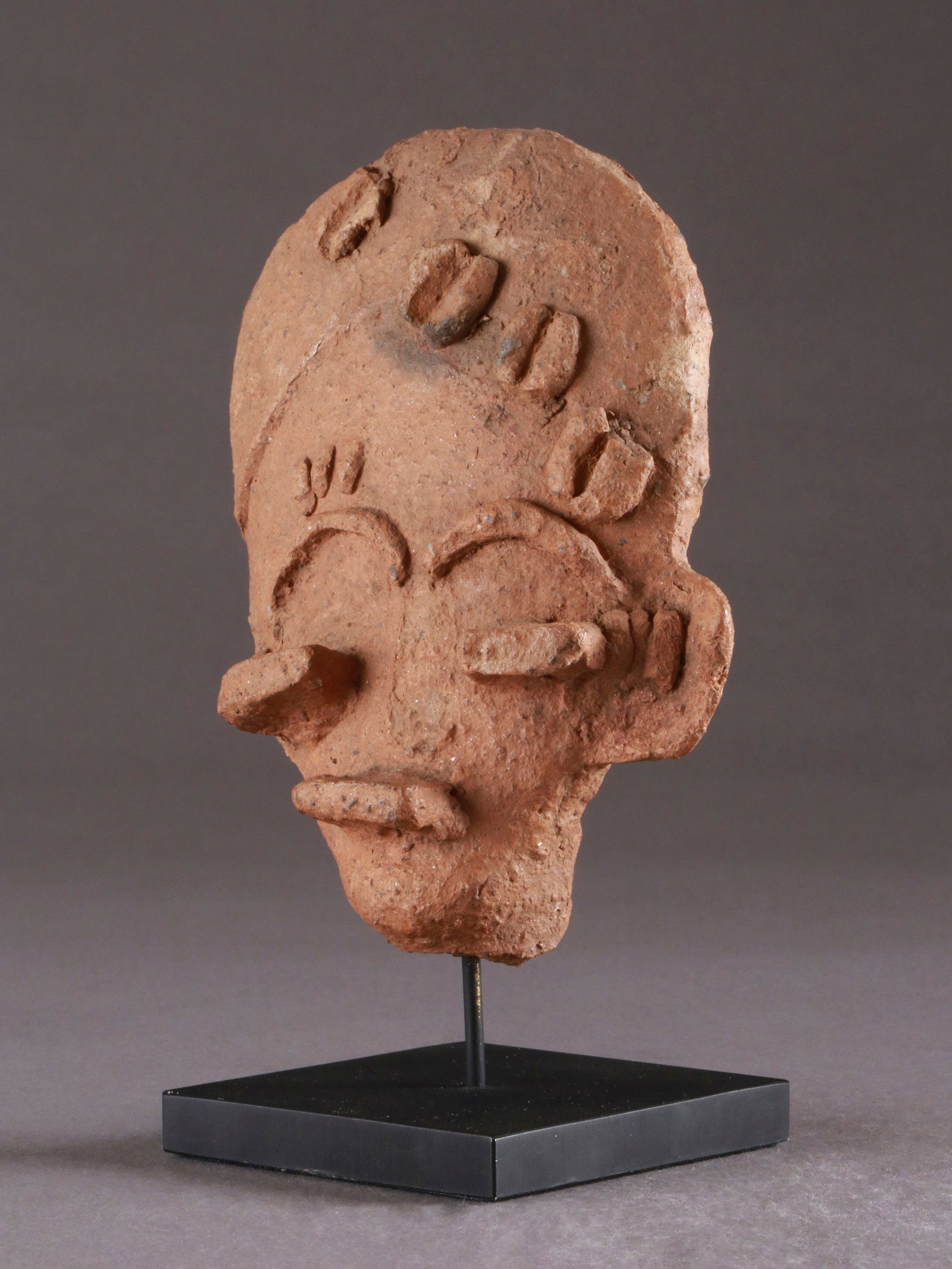 An Akan-Twi Head, Ahinsan-Style: Terrakotta-Kopf, Ahinsan-Stil Akan-Twi, Ghana Mit Sockel / with base Terrakotta. H 14 cm. Provenienz: - Galerie Walu, Zürich (vor 1990). - Jean David, Basel (1991). Publiziert: Baum, Peter (1990)