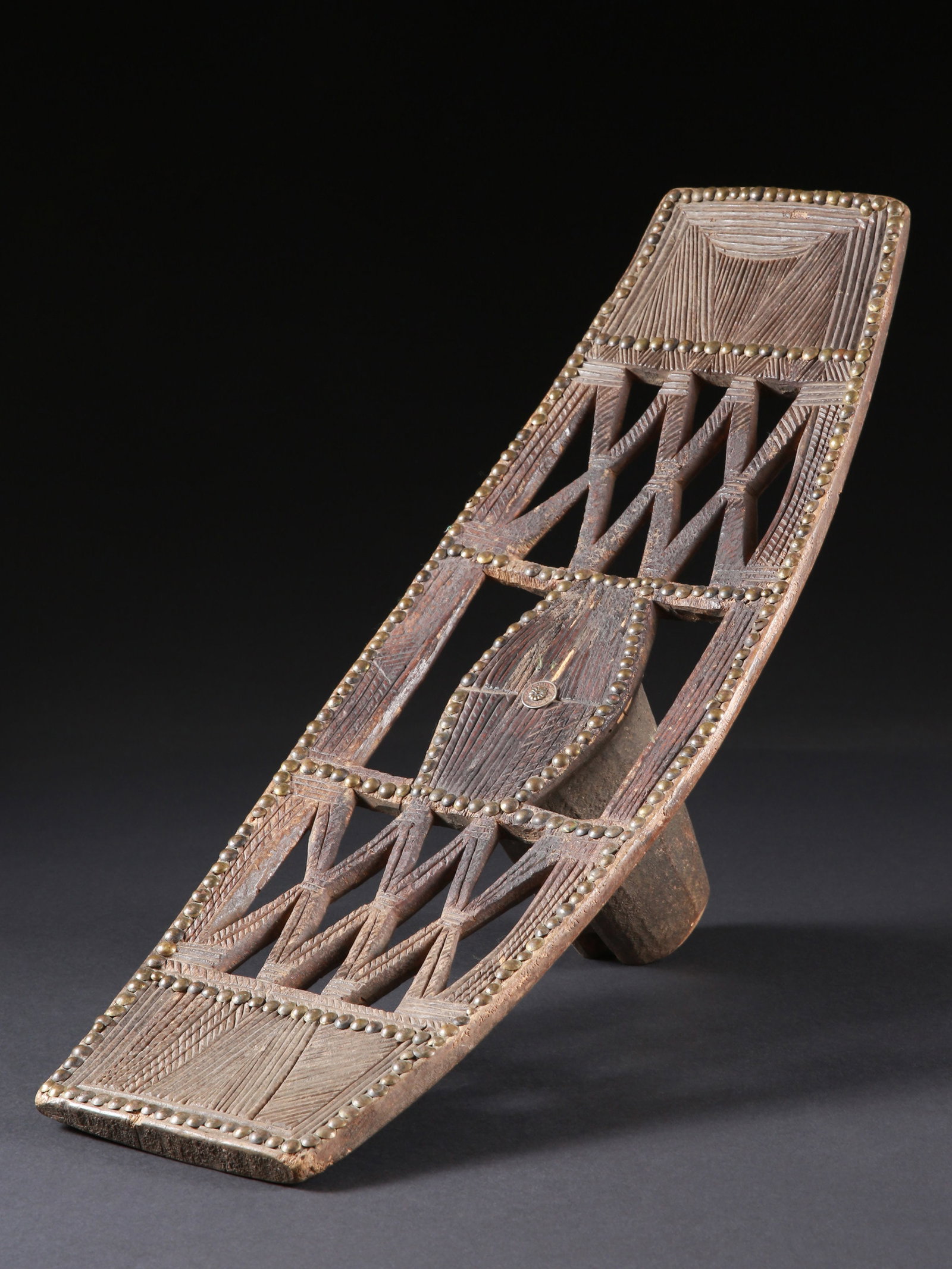 A Ngombe Stool and Backrest: Rückenstütze und Sitz Ngombe, DR Kongo Ohne Sockel / without base Holz, Polsternägel. H 38 cm. L 65 cm. Provenienz: Gérald Minkoff (1937-2009) und Muriel Olesen (1948-2020), Genf. 