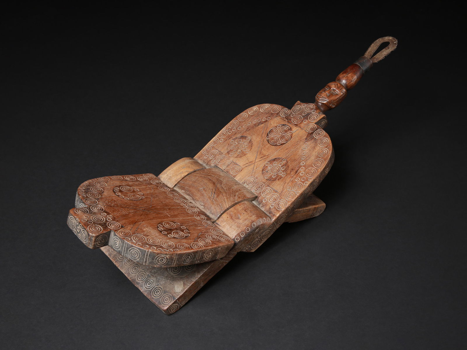 A Zaramo Folding Coconut-Grater Stool, "imbuchi": Klappstuhl mit Kokosnuss-Reibe, "imbuchi" Makonde, Tansania Ohne Sockel / without base Holz, Eisen. H 19,5 cm. L 57,5 cm. Provenienz: - Nyanza Gallery, Ula & Sten Siwmark. - Gérald Minkoff (1937-