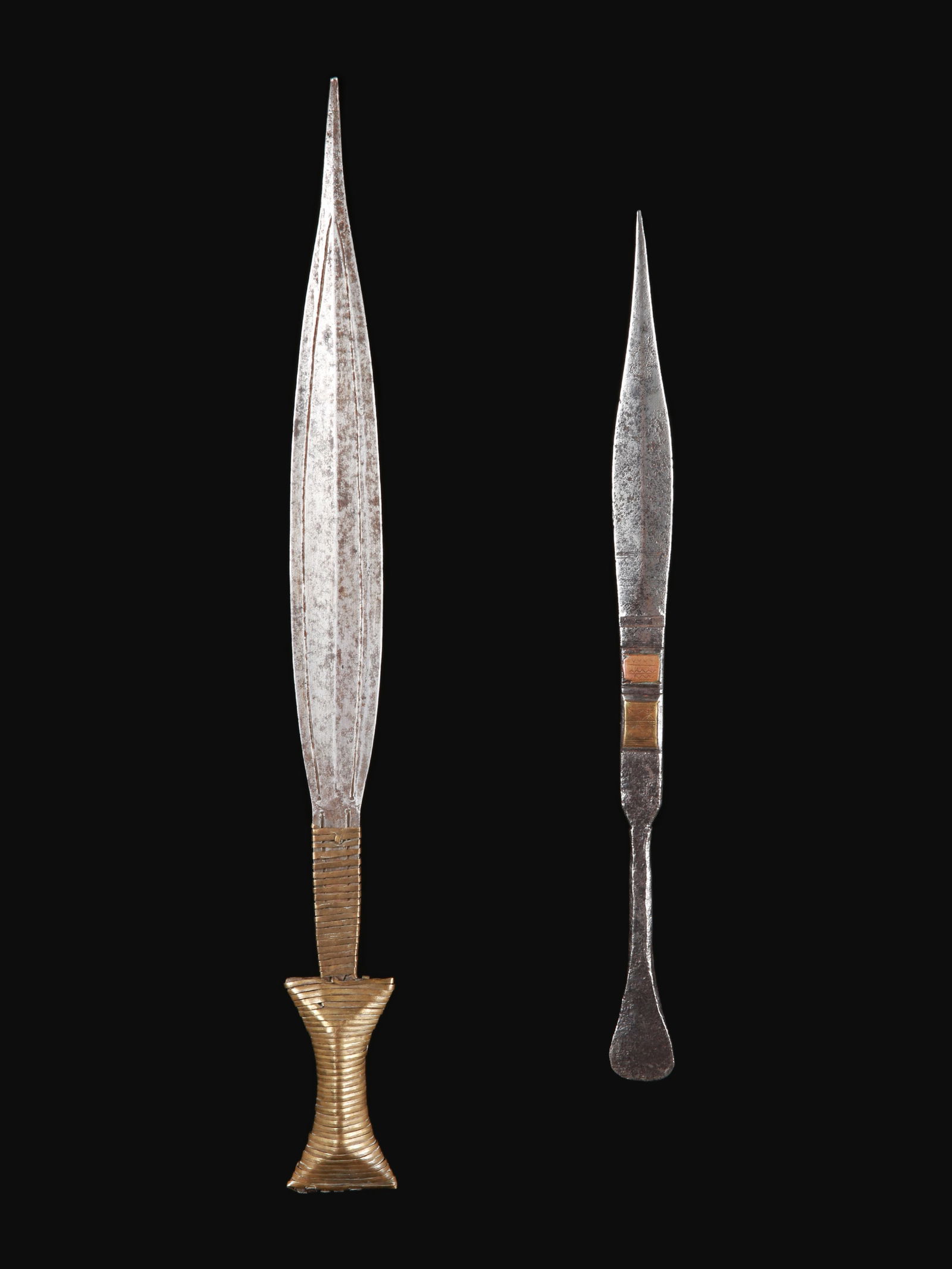 A Boa Short Sword and a Binja (?) Scarification Blade: Kurzschwert und Skarifikationsklinge Boa, Angba, Hanga, Binja, DR Kongo Ohne Sockel / without base Eisen, Kupferlegierung. H 33 - 42 cm. Provenienz: Gérald Minkoff (1937-2009) und Muriel Olesen (