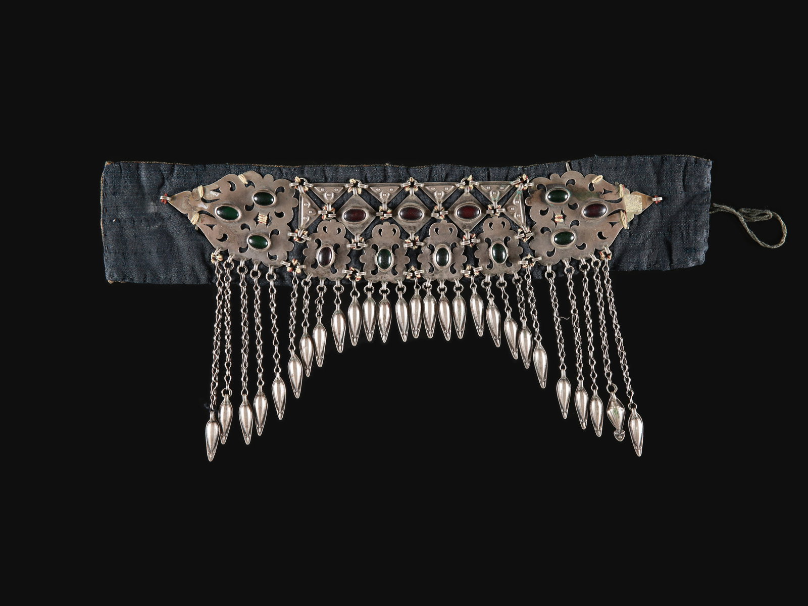 A Tekke Decoration of a girl's Hood, "ildirgitsch schelpeli": Verzierung einer Mädchenhaube, "ildirgitsch schelpeli" Tekke. Turkmenistan Ohne Sockel / without base Silber, Glasperlen. H 19,5 cm. L 39,5 cm. Provenienz: Gérald Minkoff (1937-2009) und Mur