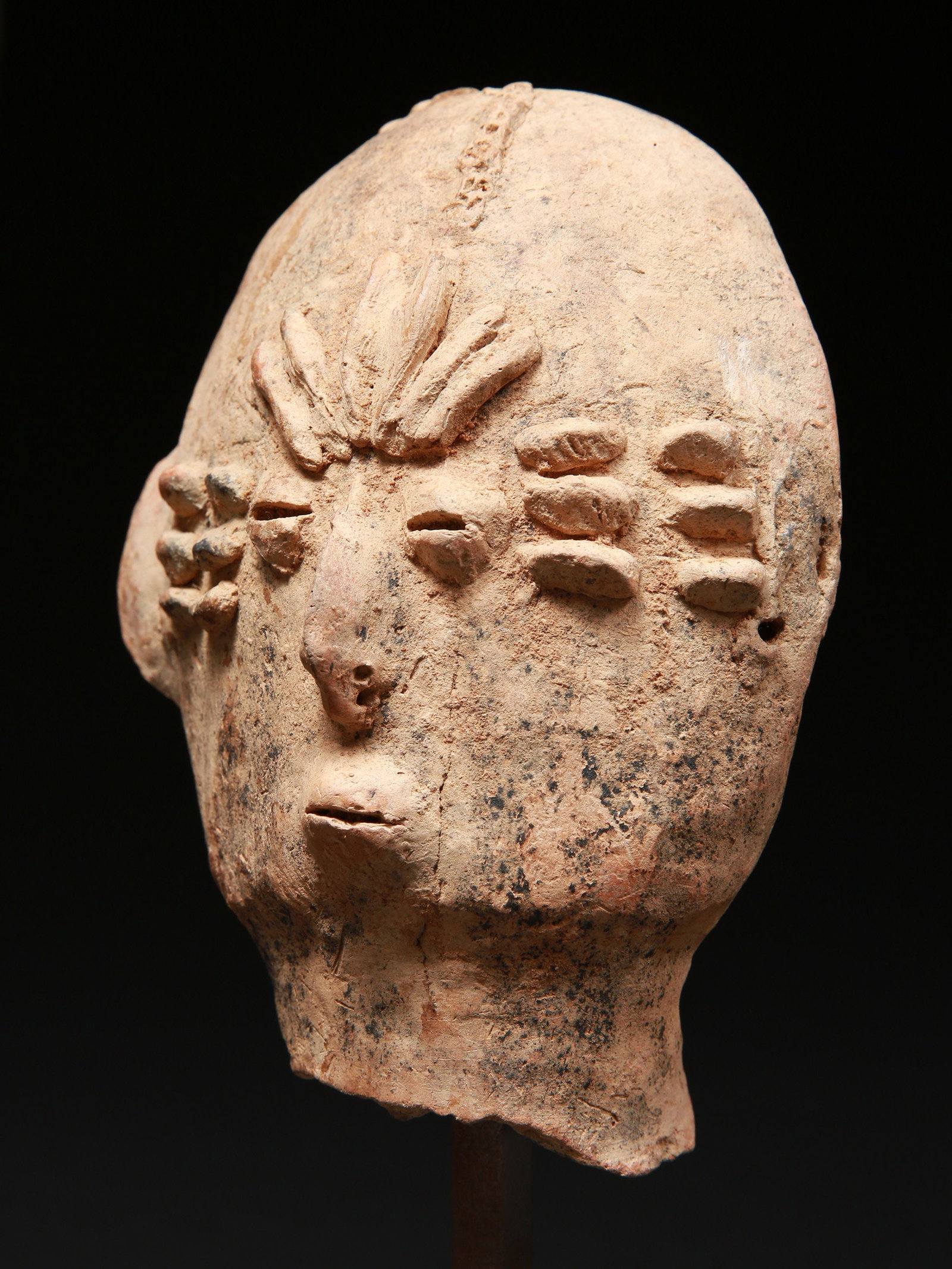 A Bura-Asinda-Sikka anthropomorphic Head: Anthropomorpher Kopf Bura-Asinda-Sikka Kultur. Niger Mit Sockel / with base Terrakotta. H 18 cm. Provenienz: Schweizer Privatsammlung, Basel. Kopf einer phallischen Tonglocke, die als Grabwächter