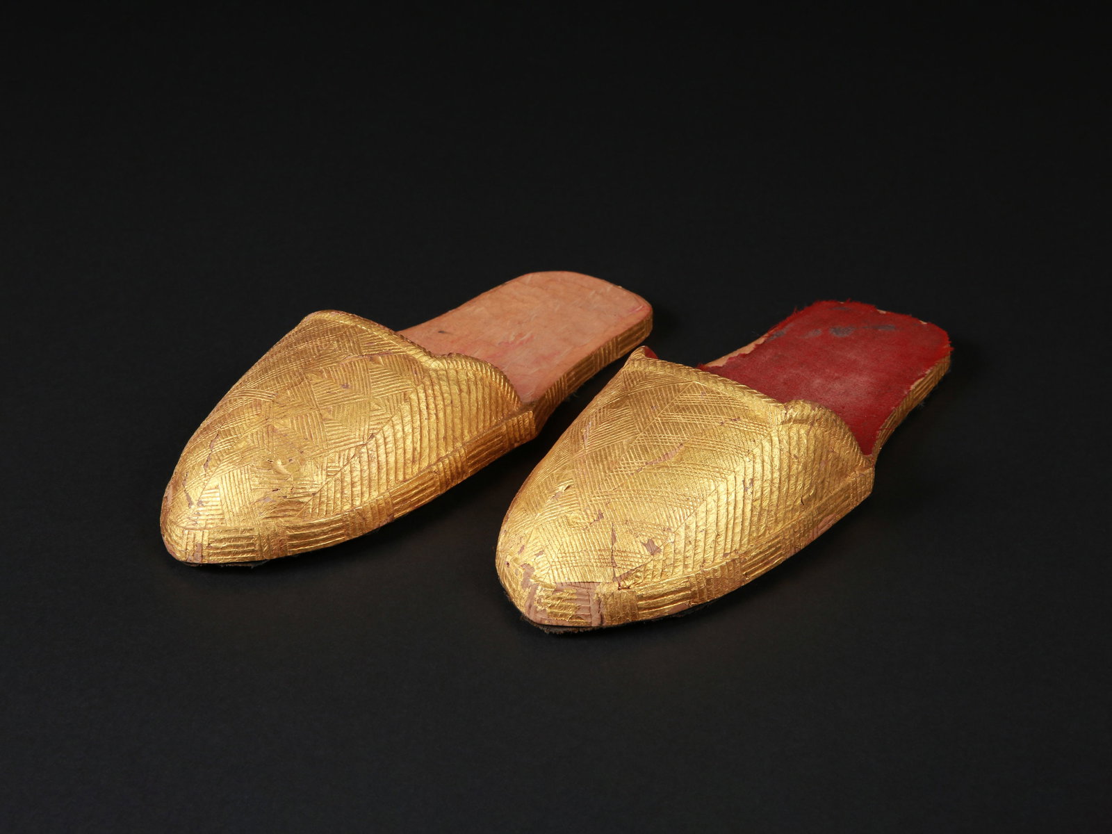 An Akan courtly Pair of Shoes: Höfisches Schuhpaar Akan. Côte d’Ivoire Ohne Sockel / without base Holz, mit Goldfolie überzogen. L 28 cm. Provenienz: - Galerie Noir d'Ivoire, Paris. - De Baecque, Paris, 10.10.2