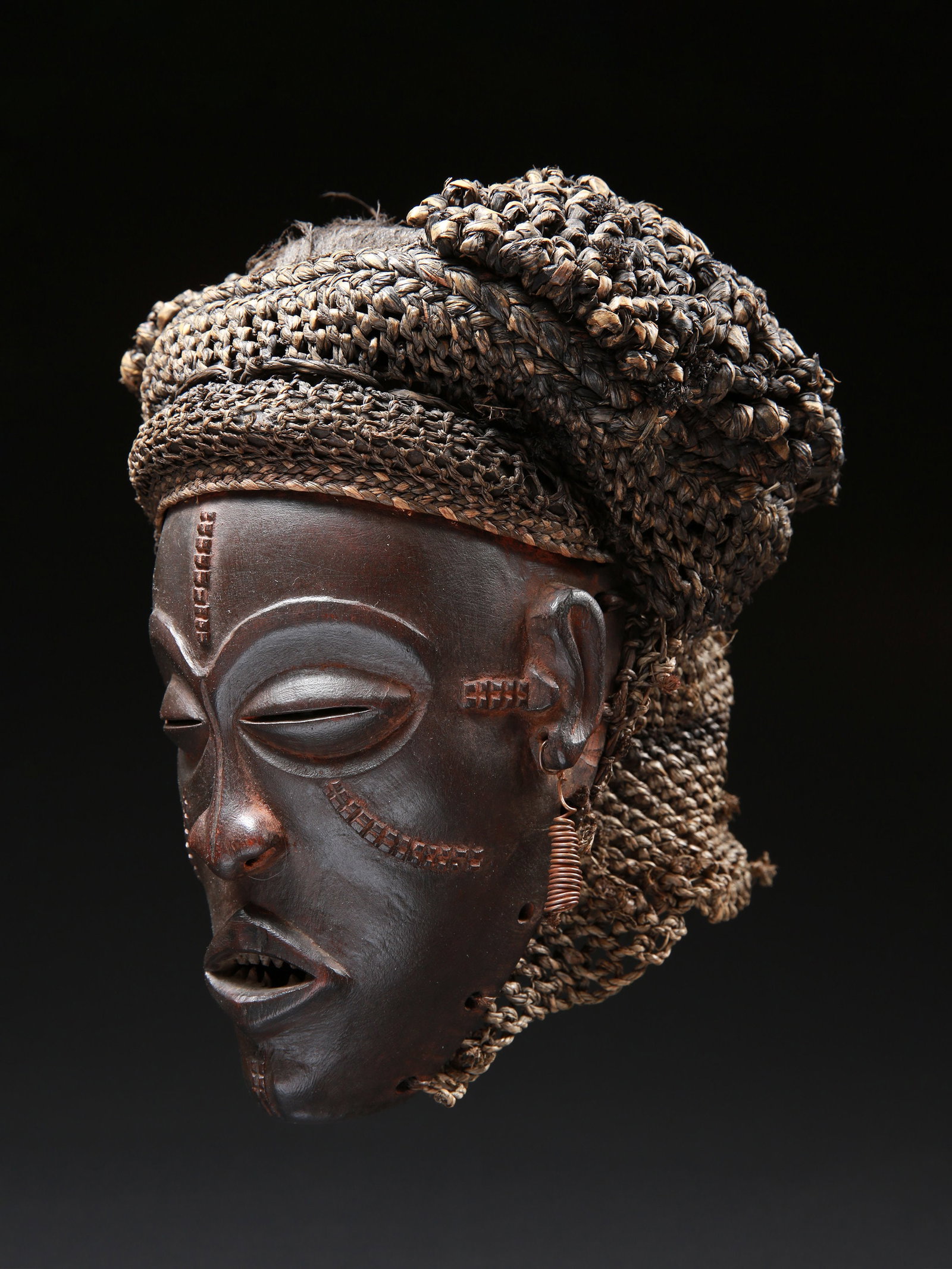 A Chokwe Mask, Handicraft: Maske, Kunstgewerbe Chokwe. DR Kongo Ohne Sockel / without base Holz, Raphia. H 22 cm. Provenienz: - Galerie D’un monde à l’autre, Claude-Alain Siegler, Lausanne. - Schweizer Privatsa