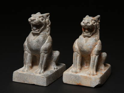 A Chinese Pair of seated Stone Lions, Tang Dynasty (?): Sitzendes L&#246;wen-Paar aus Kalkstein Tang-Dynastie (?). China Ohne Sockel / without base Stein. H 16 cm. Provenienz: Schweizer Privatsammlung, Genf. CHF 1 000 / 2 000