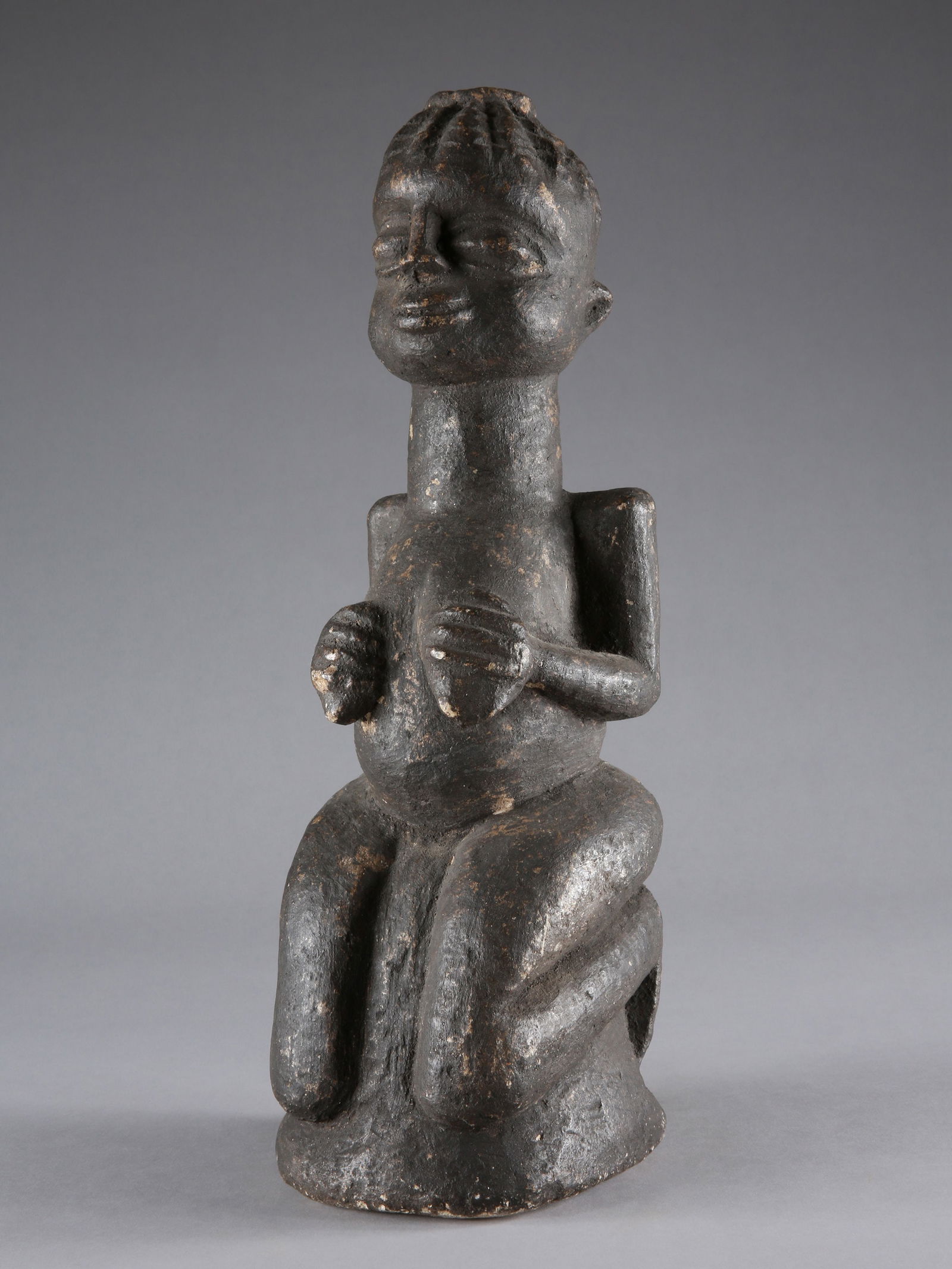 A Yoruba kneeling Stone Shrine Figure: Knieende Schreinfigur Yoruba. Nigeria Ohne Sockel / without base Stein. H 43 cm. Provenienz: - Franco Monti (1931-2008), Milano. - Alberto Galaverni (1933-2013), Parma. - Koller Auktionen, Genf (11.12
