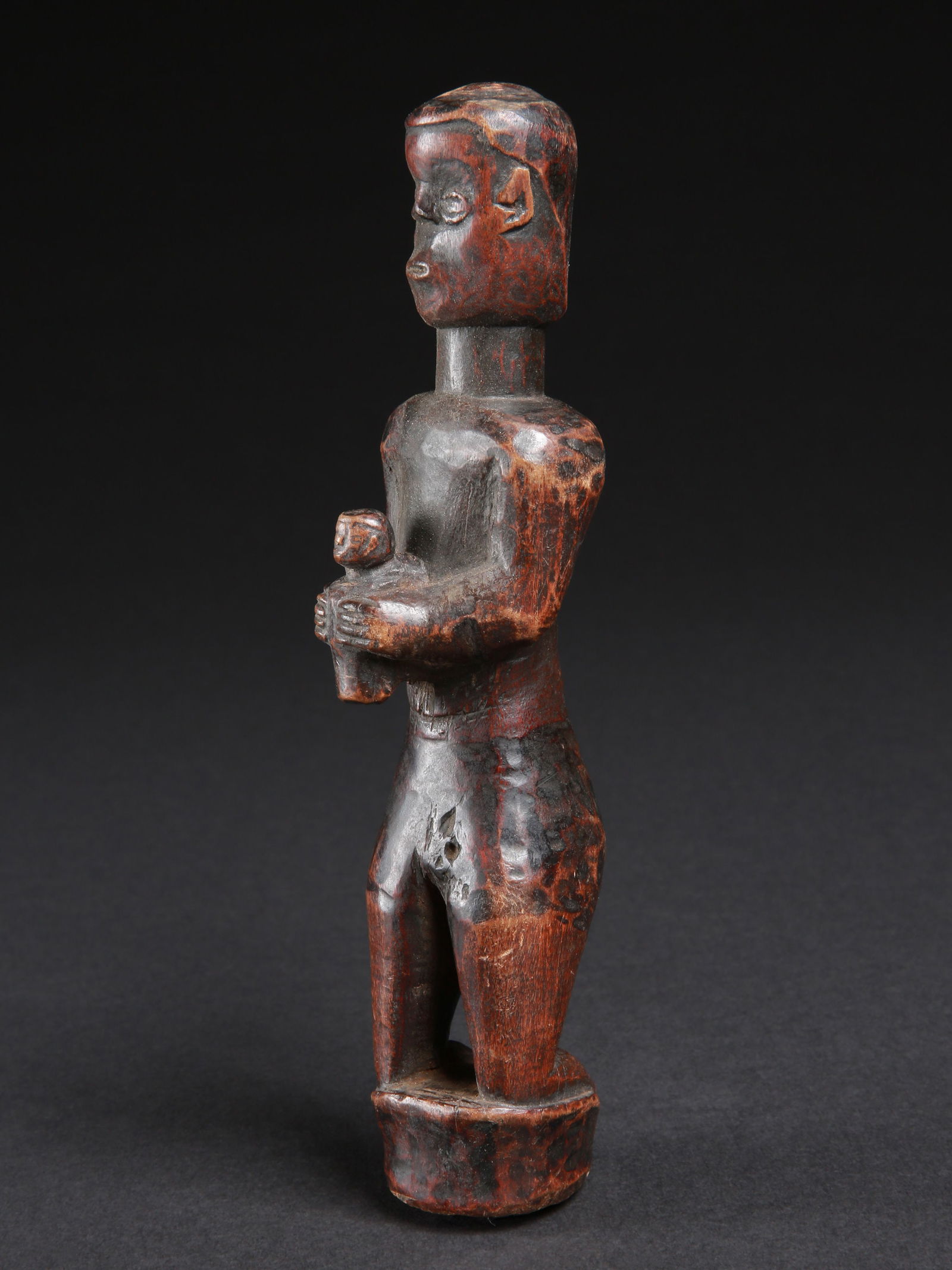 A Fipa (?) Christian Figure, kneeling Man holding a child: Christliche Votivfigur, knieender Mann der ein Kind hält Fipa (?). Tansania A Luba Christian Votive Figure Ohne Sockel / without base Holz. H 21 cm. Provenienz: - Edmond (Edi) Remondino, Burundi