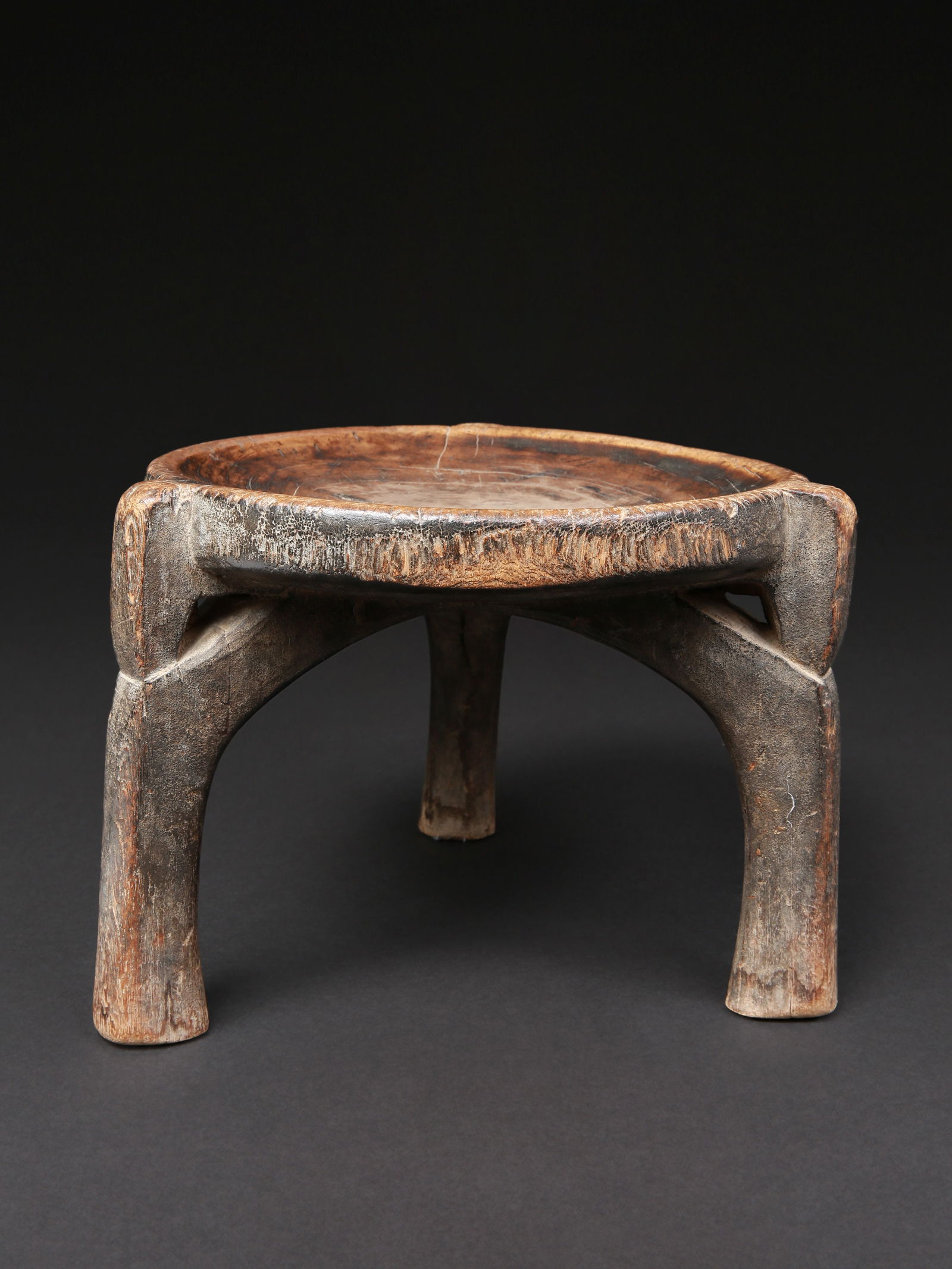 A Hehe three-legged Stool: Dreibeiniger Sitz Hehe. Tansania Ohne Sockel / without base Holz. H 20 cm. B 26 cm. Provenienz: - Charles Sollberger (1924-2014), Biel. - 1994: Schweizer Privatsammlung, Solothurn. Die Verbindung von
