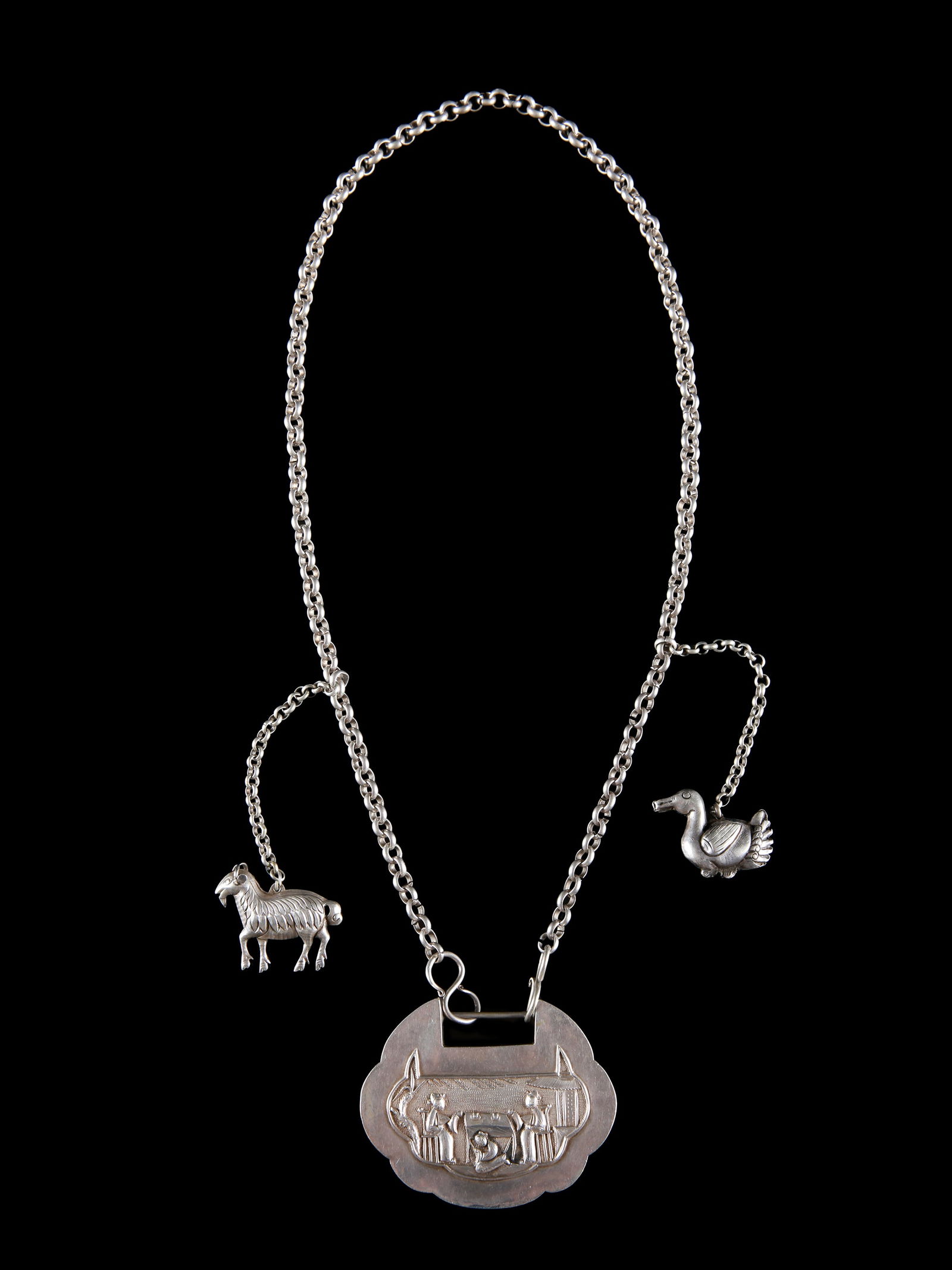 3 Qing-Dynasty Amulets on a Necklace: 3 Amulette an einem Collier Qing-Dynastie. China Ohne Sockel / without base Silber. H Anhänger: 6,5 cm. B Anhänger: 8,5 cm. L 42 cm. Provenienz: Schweizer Privatsammlung, Bern. CHF 150 / 300