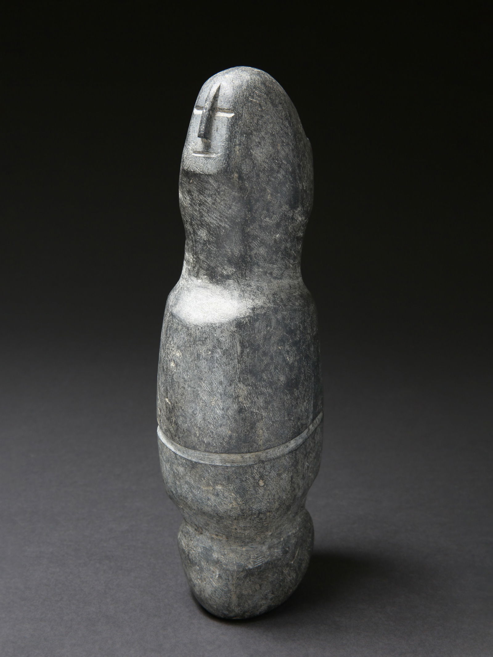 An Inuit Stone Figure, most likely by Andy Miki (1918-1983): Steinfigur, höchstwahrscheinlich von Andy Miki (1918-1983) Inuit. Kanada / Eskimo Point / Arviat Ohne Sockel / without base Stein. H 32 cm. B 14 cm. Provenienz: 1975: Schweizerische Privatsammlung, A