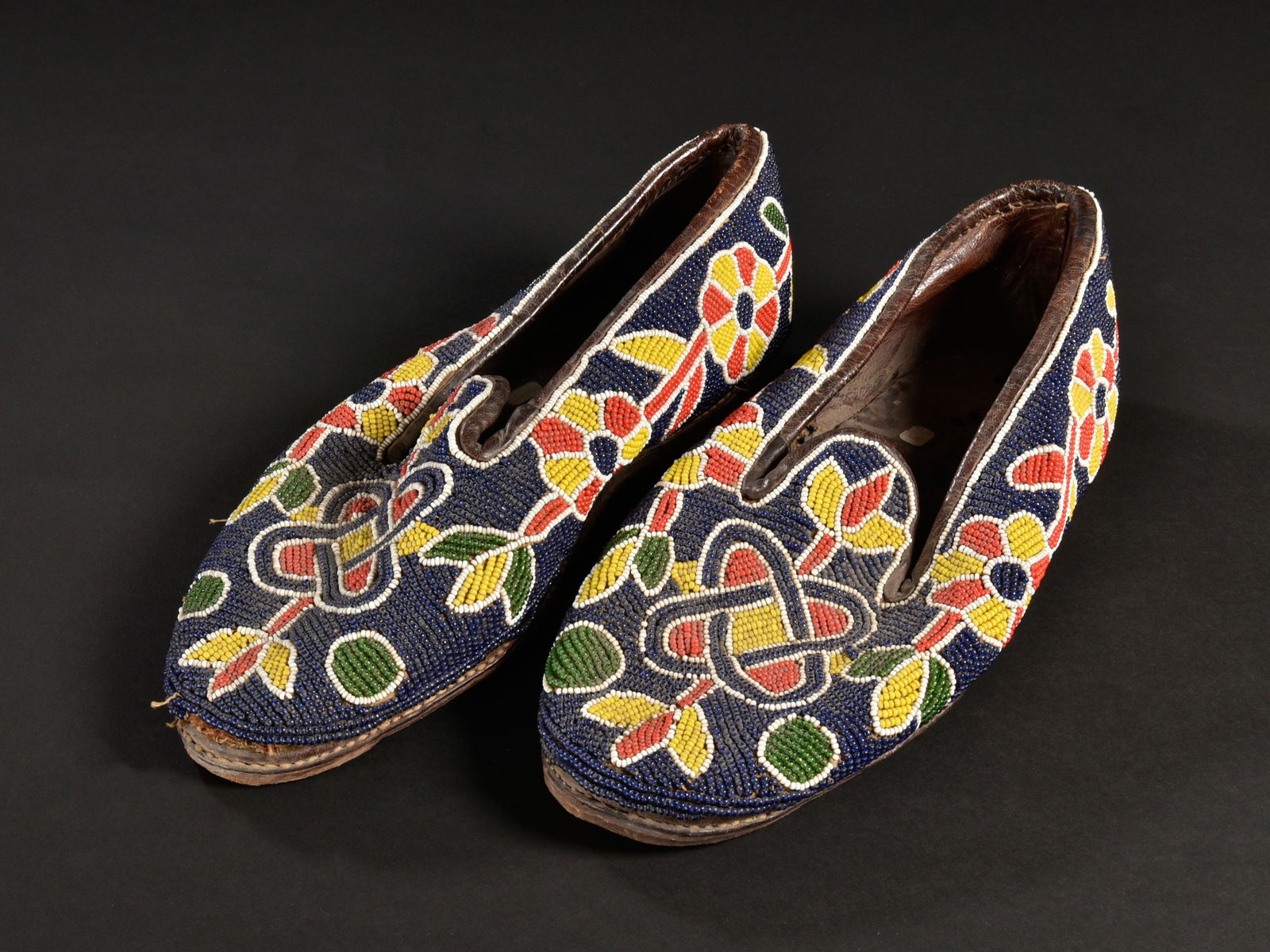 A Pair of beaded Yoruba Shoes, "bata ileke": Schuhpaar perlenbestickt, "bata ileke" Yoruba. Nigeria Ohne Sockel / without base Leder, Glasperlen. L je 29 cm. Provenienz: - René David (1928-2015), Zürich. - 2015: Jean David, Basel. - Ha