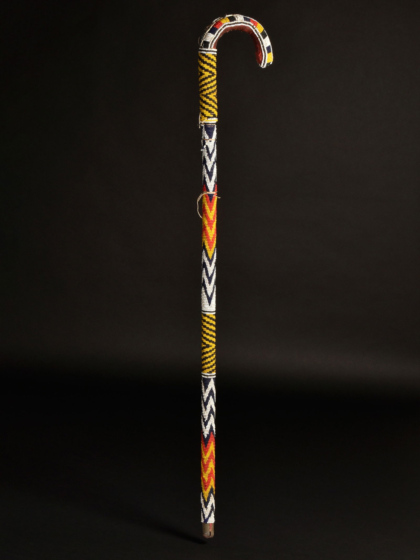 A Yoruba beaded Walking Stick: Mit Glasperlen verzierter Gehstock Yoruba. Nigeria Ohne Sockel / without base Holz, mit Glasperlen überzogen. H 96,5 cm. Provenienz: - René David (1928-2015), Zürich. - 2015: Jean David, Basel.