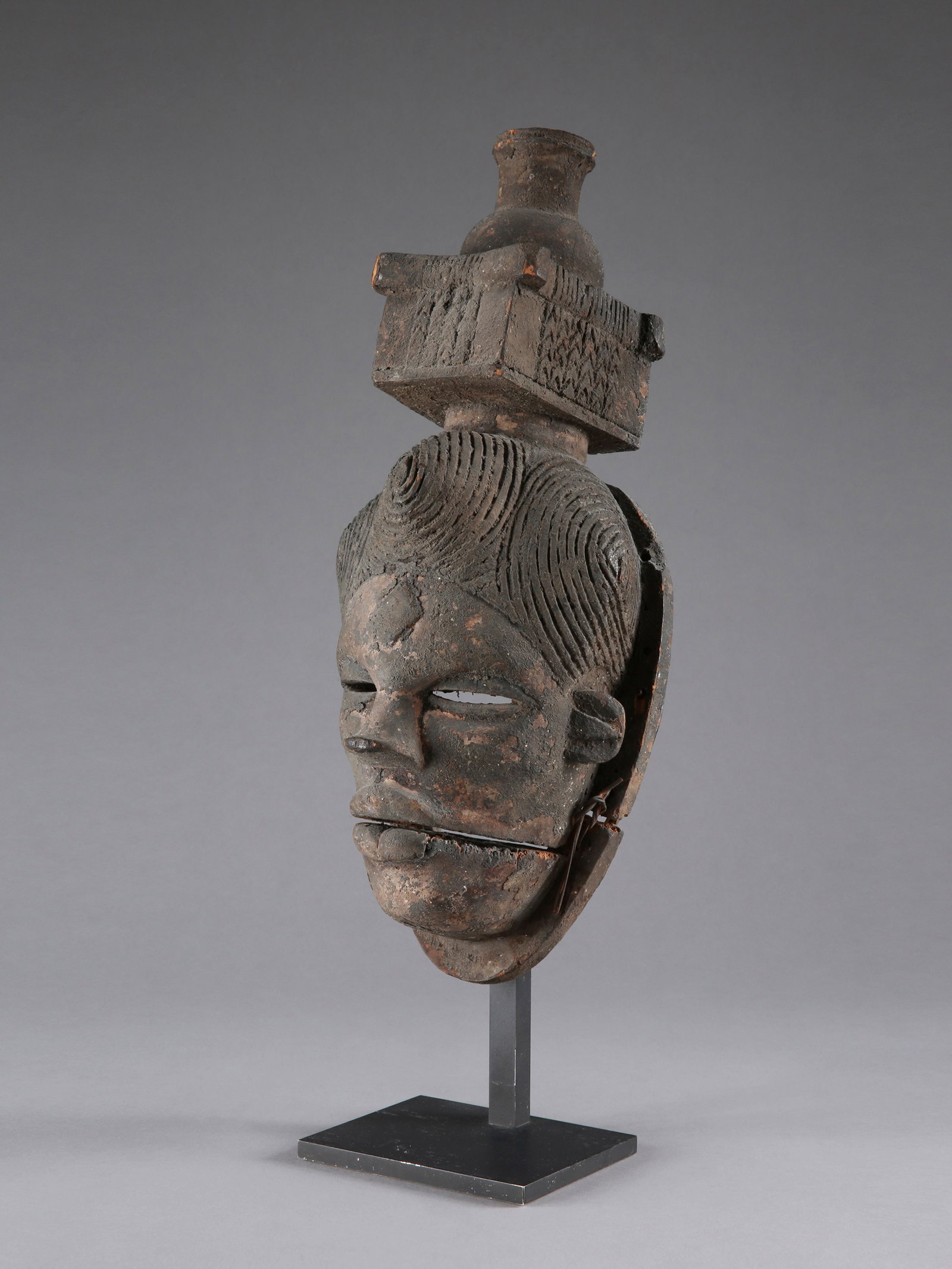 An Ogoni Mask, "elu": Maske, "elu" Ogoni. Nigeria Mit Sockel / with base Holz, Pflanzenfasern. H 38,5 cm. B 15 cm. Provenienz: - Emil Storrer (1917-1989), Zürich. - Galerie Walu, Zürich. 2010 erworben. -