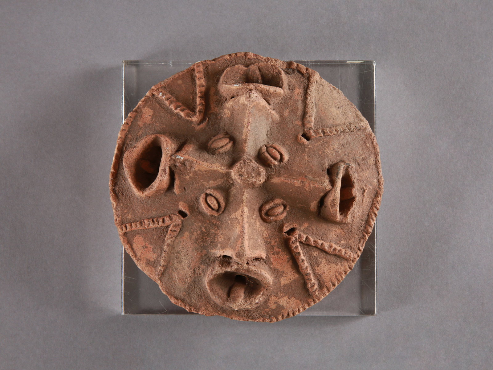 A Koma-Bulsa Disc with four Faces, "kronkronbua": Scheibe mit vier Gesichtern, "kronkronbua" Koma-Bulsa Kultur. Ghana Mit Sockel / with base Terrakotta. Ø 14 cm. Provenienz: Galerie Walu, Zürich (vor 1987). Thermolumineszenz-Altersbestimmun