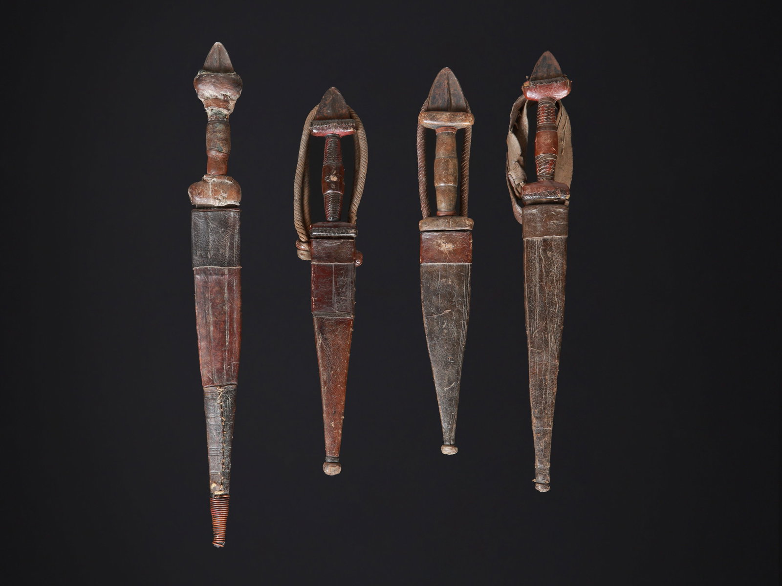 4 Tuareg Daggers with Sheaths: 4 Dolche mit Scheiden Tuareg. Sahelzone Ohne Sockel / without base Holz, Eisen, Leder. L 29 - 38 cm. Provenienz: Laurence und Jean-Pierre Boillod (1929-2007), Areuse. Zeremonialwaffen zeichnen sich