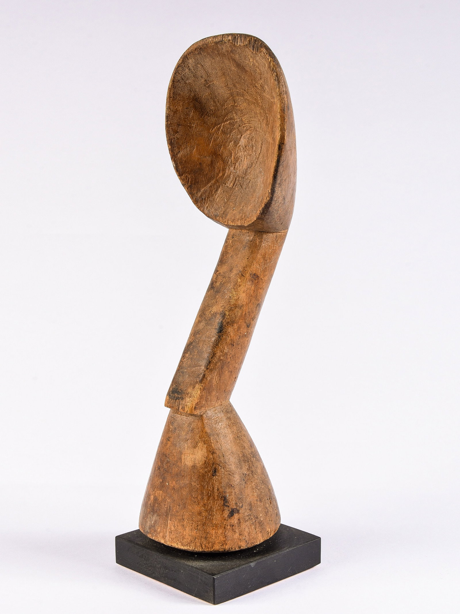An Akan Spoon and Pestle: Skulpturaler Löffel-Stössel Akan, pestle-shaped handle. Côte d’Ivoire Mit Sockel / with base Holz. H 27,5 cm. Provenienz: - Galerie Walu, Zürich. - Denise Zubler