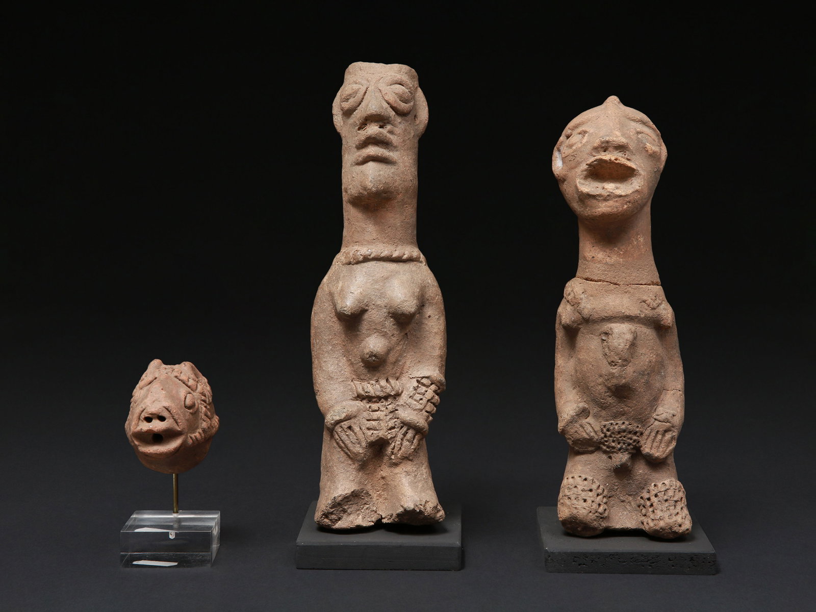 2 Koma-Bulsa seated Terracotta Figures and a head, "kronkronbua": 2 Sitzende Figuren und ein Kopf, "kronkronbua" Koma-Bulsa Kultur. Ghana Mit Sockel / with bases Terrakotta. H 7 - 25 cm. Provenienz: - Galerie Walu, Zürich. - Schweizer Privatsammlung, Bern.