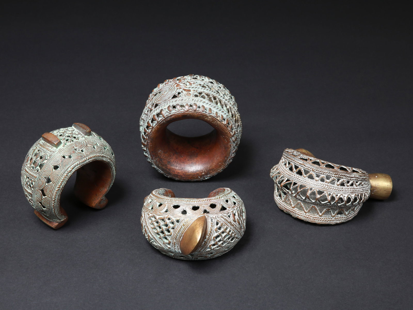 4 Grassfields Bangles, Pre-Coinage Currencies: 4 Schmuckreife, vormünzliche Zahlungsmittel Grasland, Bamun. Kamerun Ohne Sockel / without base Kupferlegierungen. Ø 12 - 14 cm. Provenienz: Schweizer Privatsammlung, Zürich. Seit
