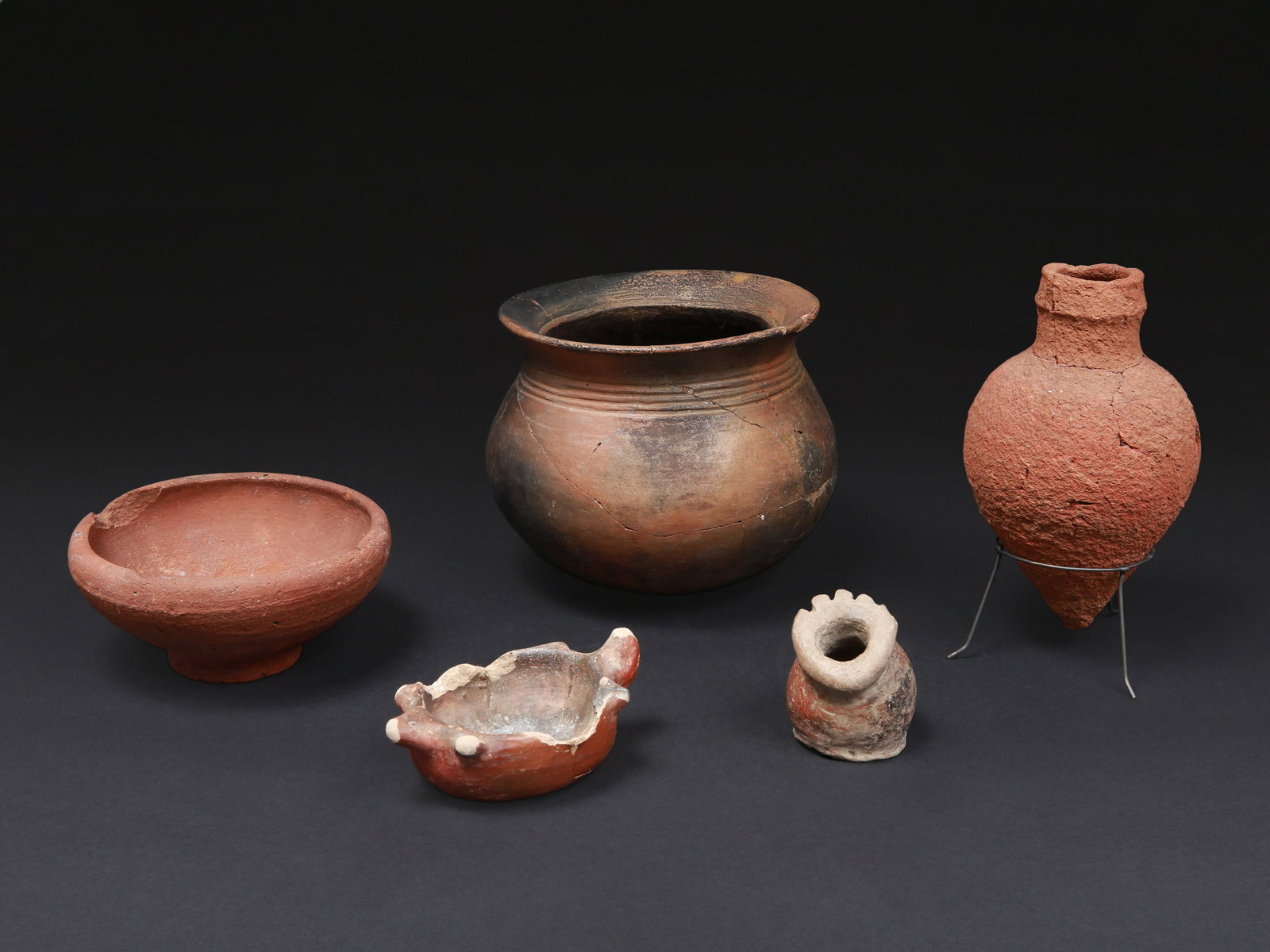Lot consisting of five Terracotta Vessels: Lot bestehend aus fünf Terrakotta-Gefässen Mit einem Sockel / with one base Terrakotta. H 7 - 14 cm. Provenienz: - vermutl. Museum Bally-Prior, Schönenwerd. - Schweizer Privatsammlung,