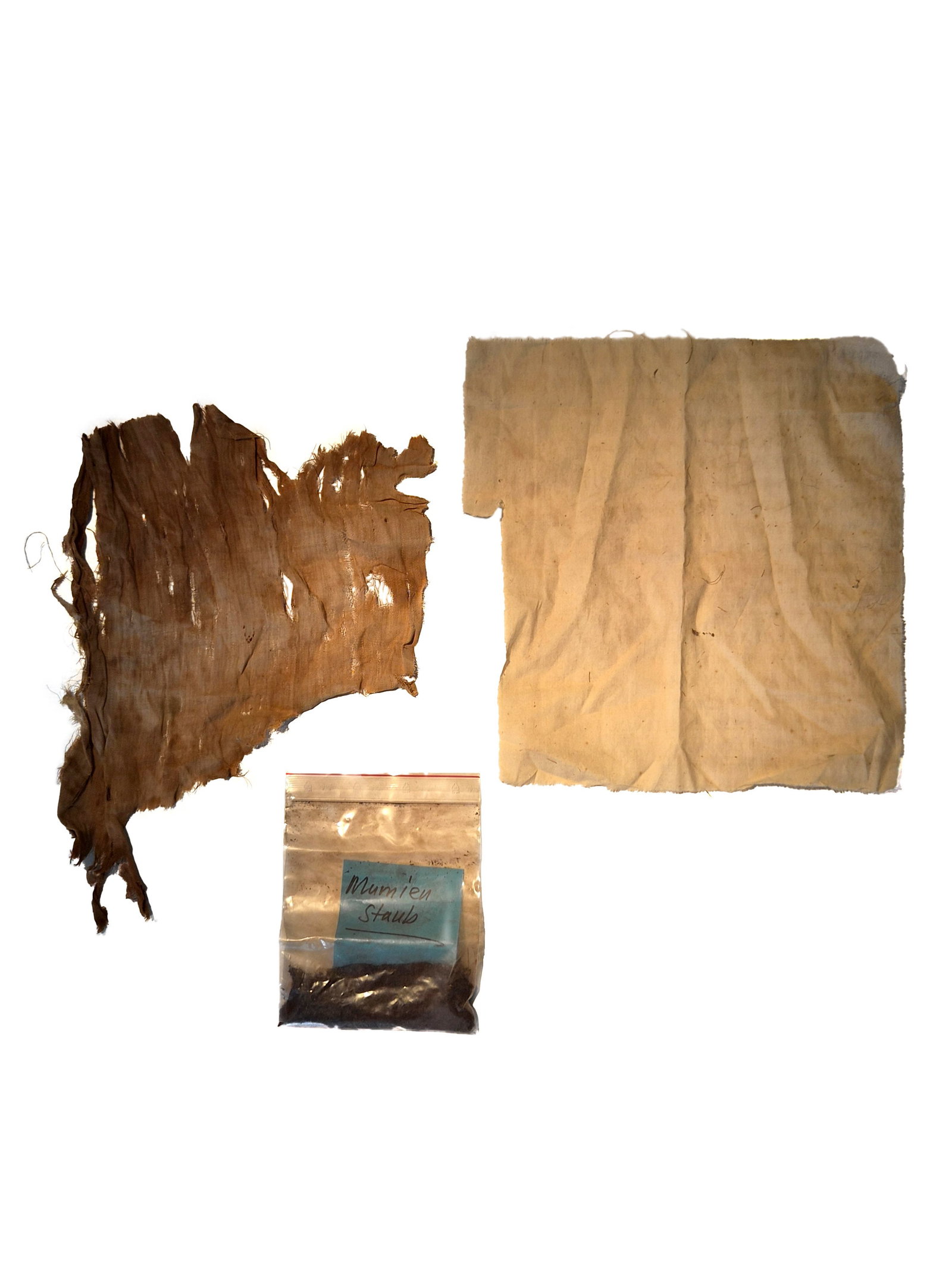 Lot consisting of two Textiles and "Mummy Dust" (?): Lot bestehend aus zwei Textilien und "Mumienstaub" (?) Ägypten Ohne Sockel / without base Baumwolle. Provenienz: - Museum Bally-Prior, Schönenwerd. - Schweizer Privatsammlung, Bern. CHF 50