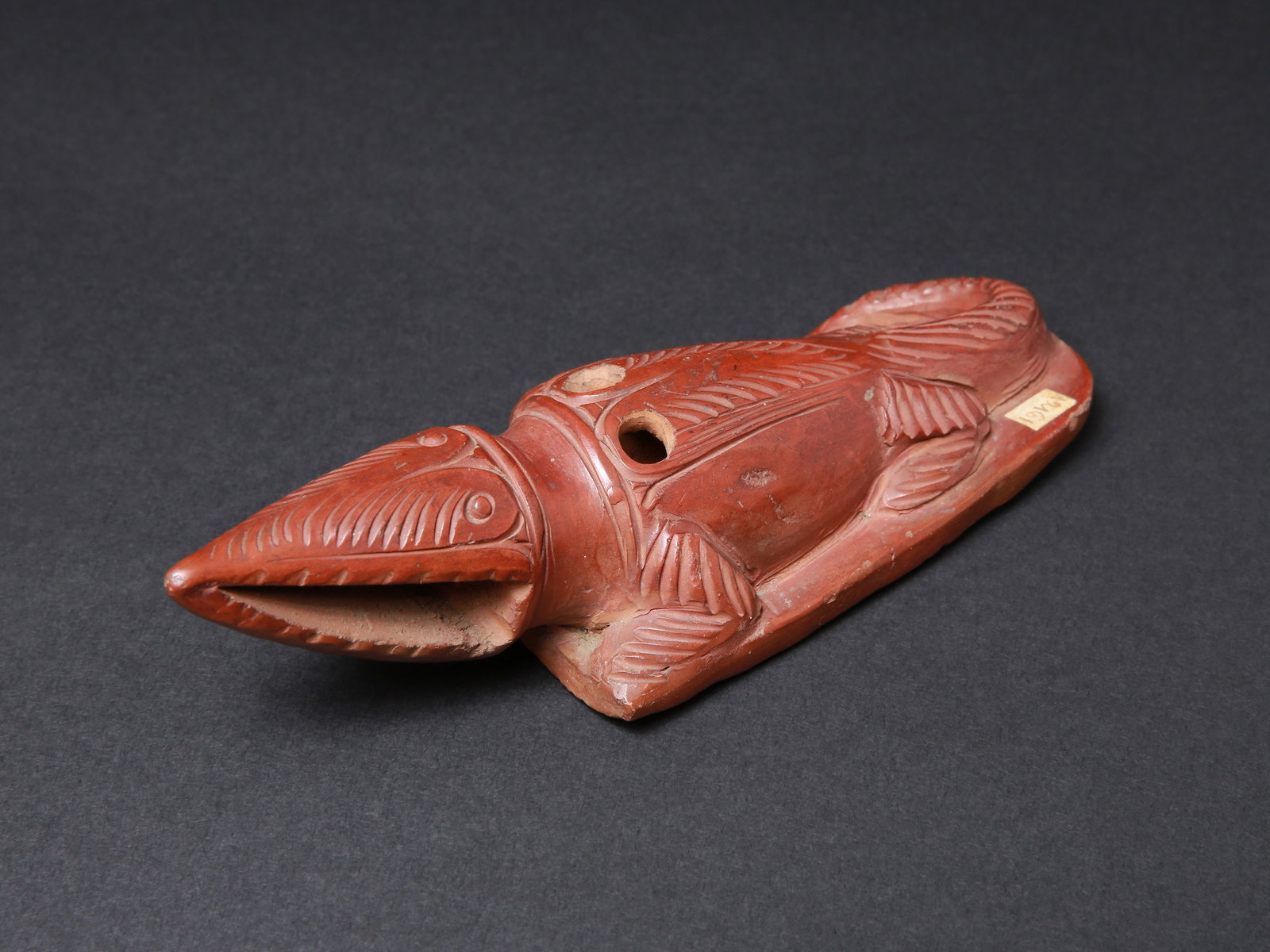 An Egyptian Foot Rasp in the form of a Crocodile: Fussraspel in Form eines Krokodils Ägypten Ohne Sockel / without base Terrakotta. H 4,5 cm. L 17,5 cm. Provenienz: - Museum Bally-Prior, Schönenwerd. - Schweizer Privatsammlung, Bern. Die