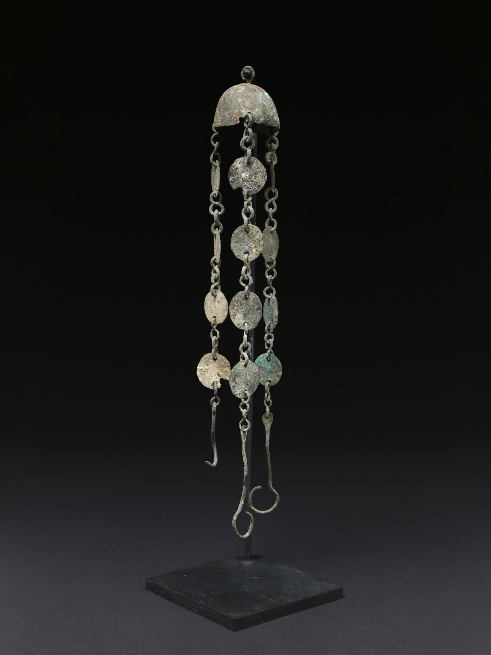 A Roman Chained Bell Holder: Glockenhalter mit Kette Römisch Mit Sockel / with base Kupferlegierung. H 48 cm. Provenienz: - englische Sammlung, Oxford. - Pax Romana Auctions, London, 01.02.2020, Lot 200. - Schweizer Privatsa