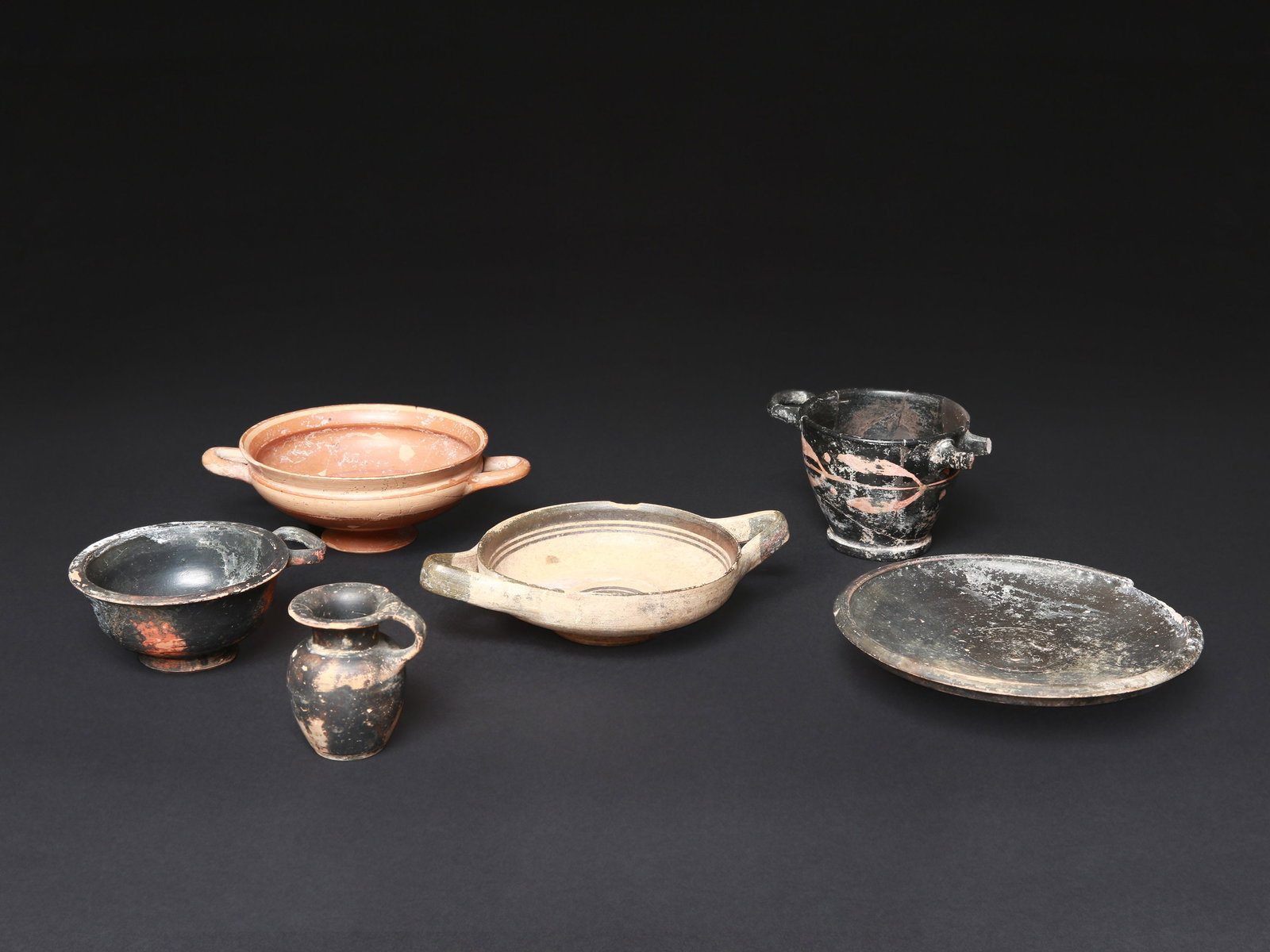 5 Greek Cups and a Vessel: 5 Schalen und ein Gefäss Griechisch Ohne Sockel / without base Terrakotta. H 3,5 - 7,5 cm. Ø 4 - 16 cm. Provenienz: Schweizer Privatsammlung, Zürich. CHF 300 / 600