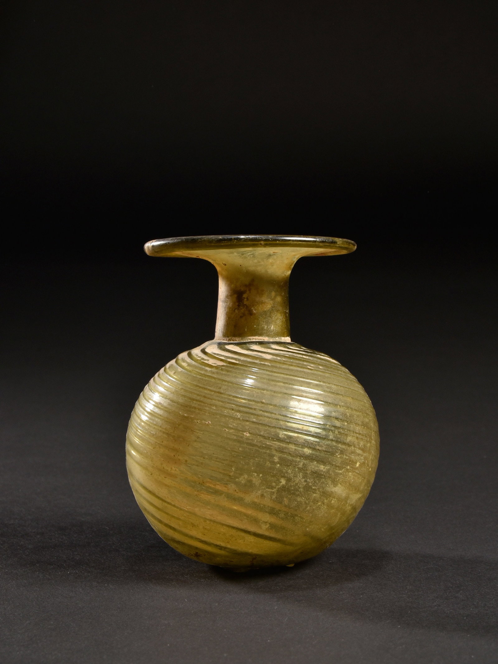 A Ribbed Sprinkler Flask: Glasflakon Östlicher Mittelmeerraum Ohne Sockel / without base Glas. H 9,5 cm. Provenienz: - Mildred Miriam Devor, Jerusalem (1960er - 1970er Jahre). - Hammer Auktionen, Basel (17.04.2019), Lot