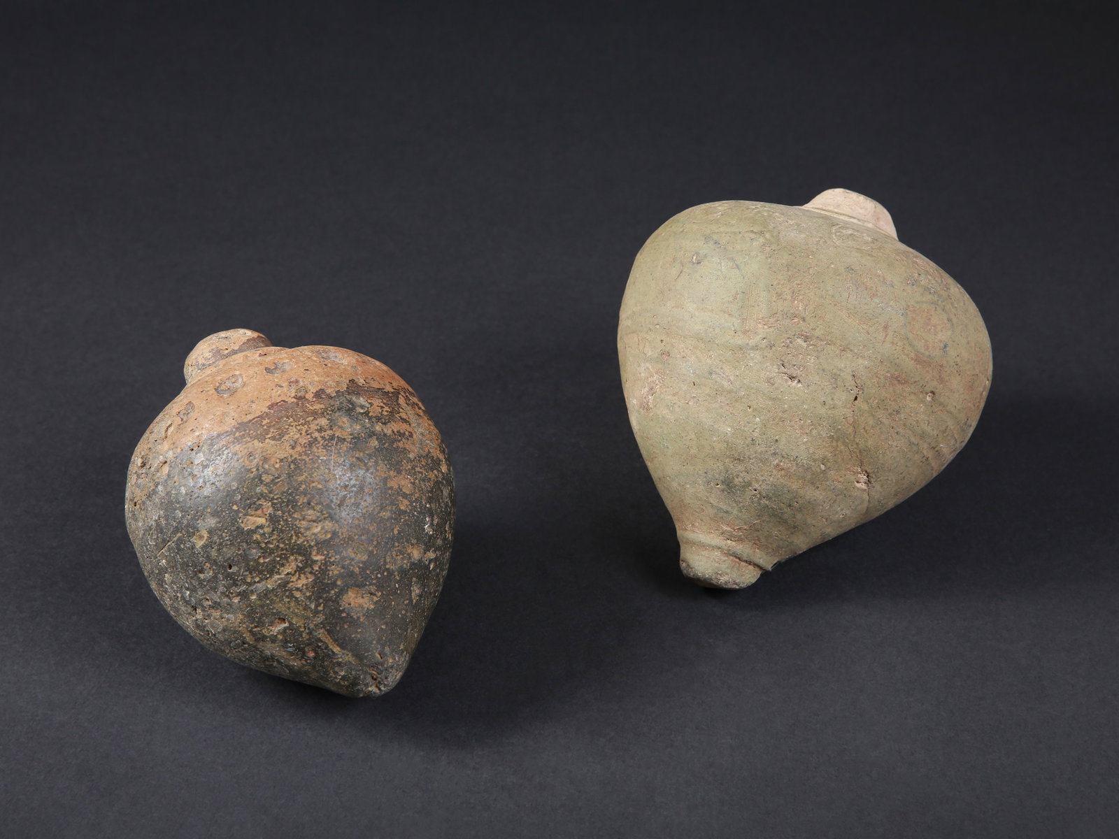 2 Byzantine Greek Fire Hand Grenades: 2 Feuerhandgranaten Byzantinisch Ohne Sockel / without base Keramik. H 13 - 13,5 cm. Provenienz: - TimeLine Auctions, Harwich, 02.06.2020, Lot 2412. - Schweizer Privatsammlung, Basel. CHF 300 / 600